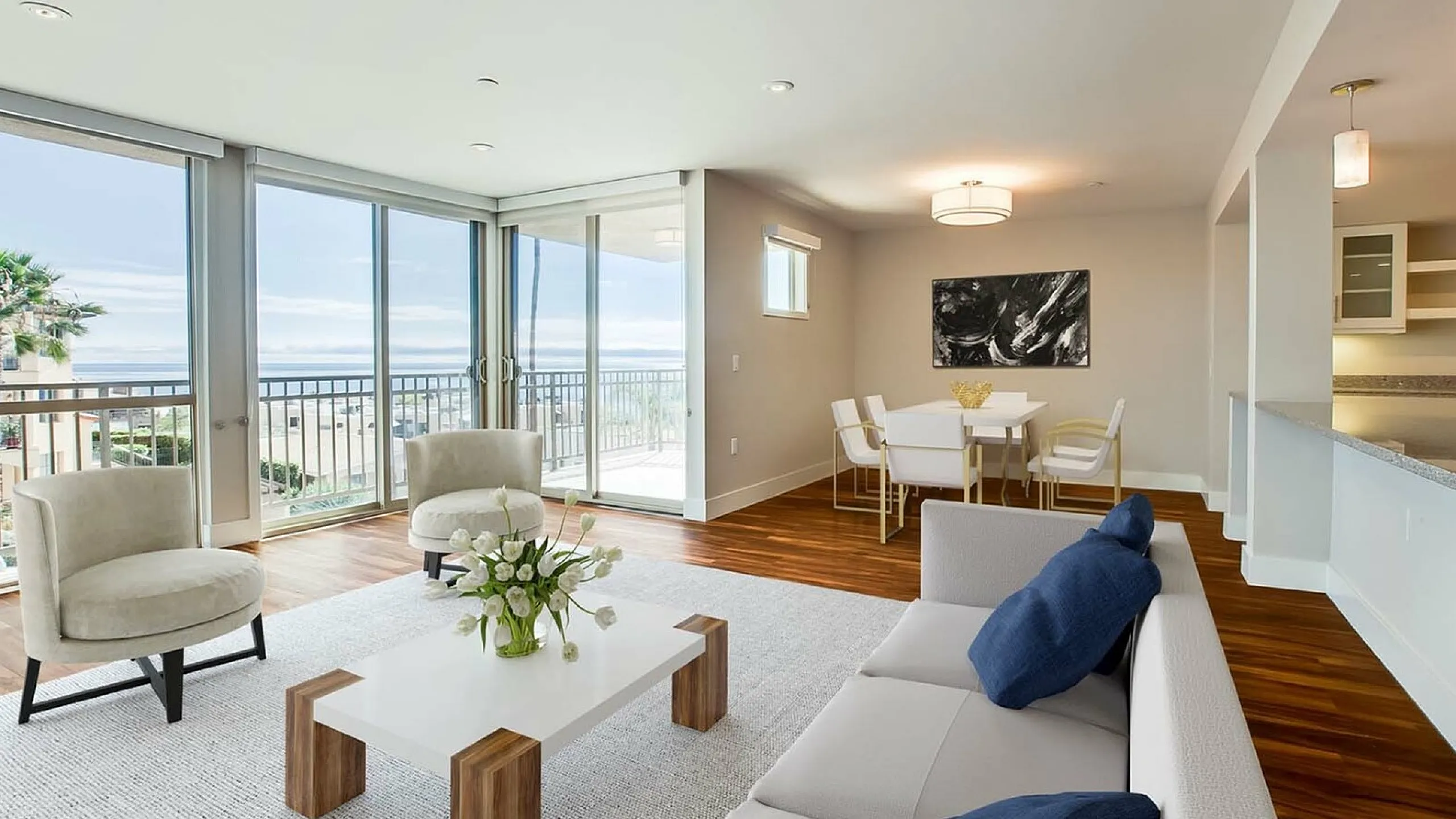 Elegant living room with panoramic ocean view, featuring modern furniture, hardwood floors, and abundant natural light.