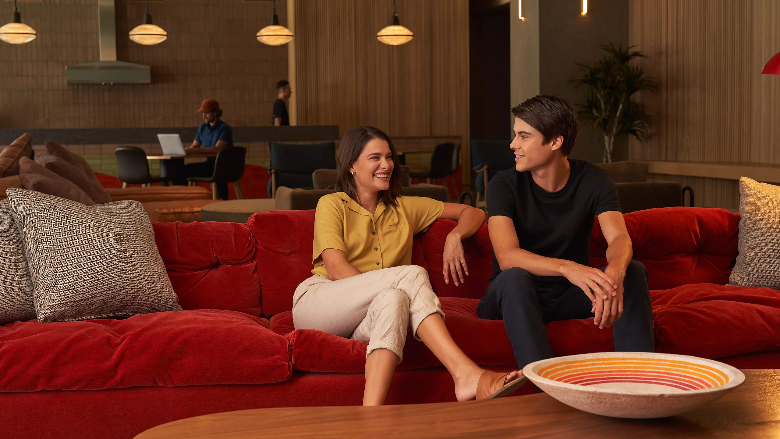 Modern lounge with plush red sofa and inviting ambiance, ideal for relaxation and socializing.