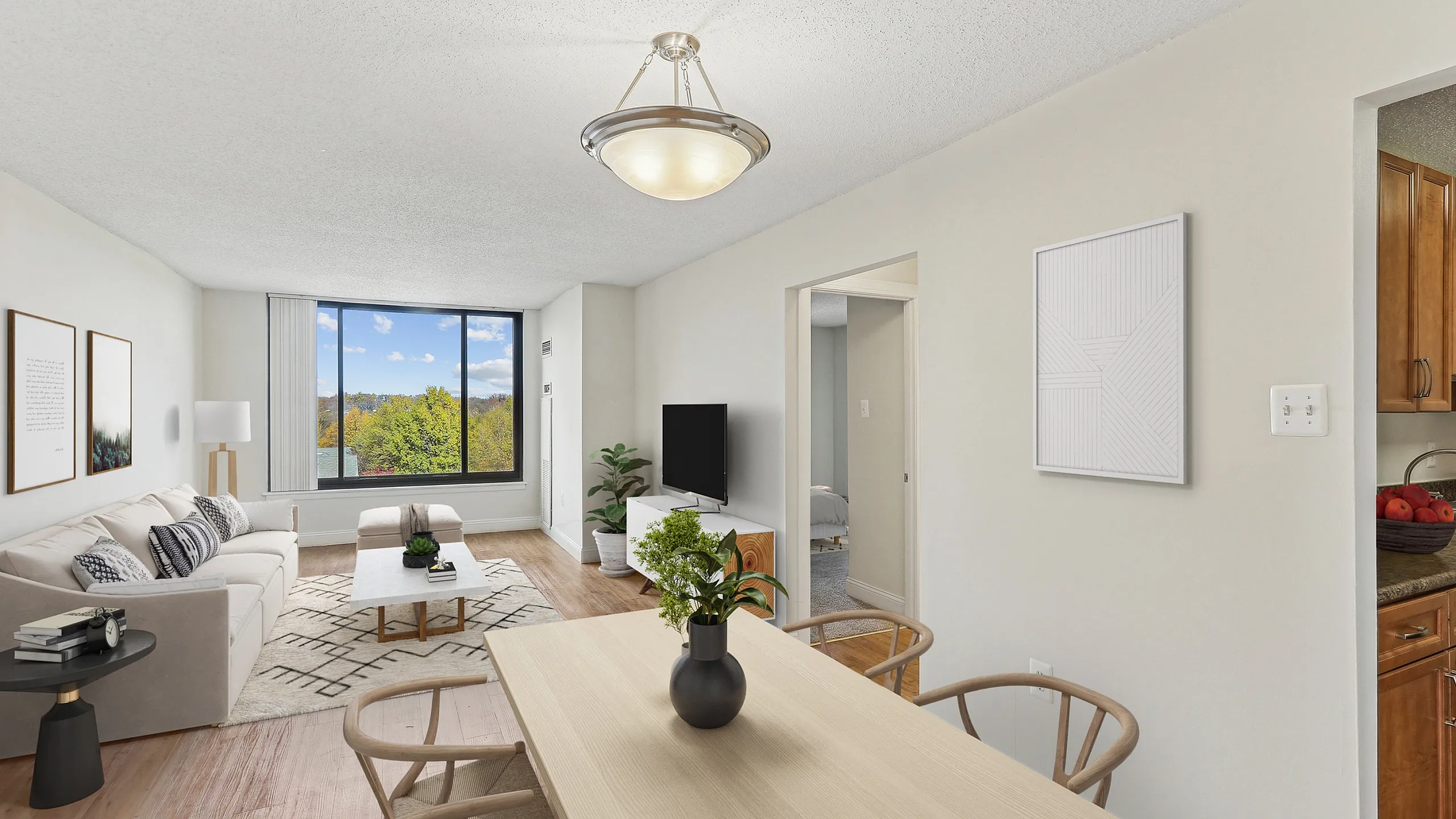 Inviting living and dining area with modern decor, large window showcasing scenic views, and cozy neutral furnishings.
