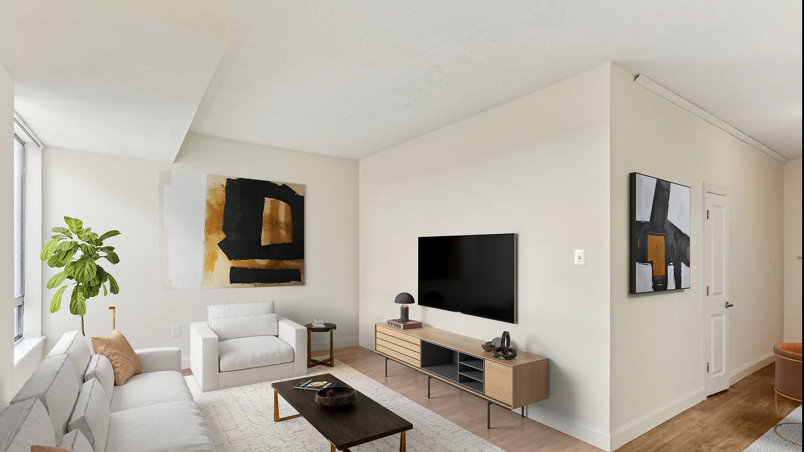 Bright, modern living room with cozy white sofas, stylish black coffee table, and sleek TV setup.