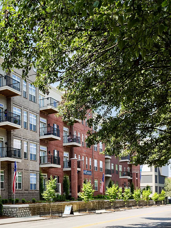 Charming urban apartment complex with brick facade, large windows, and welcoming entrance. Perfect for modern city living.