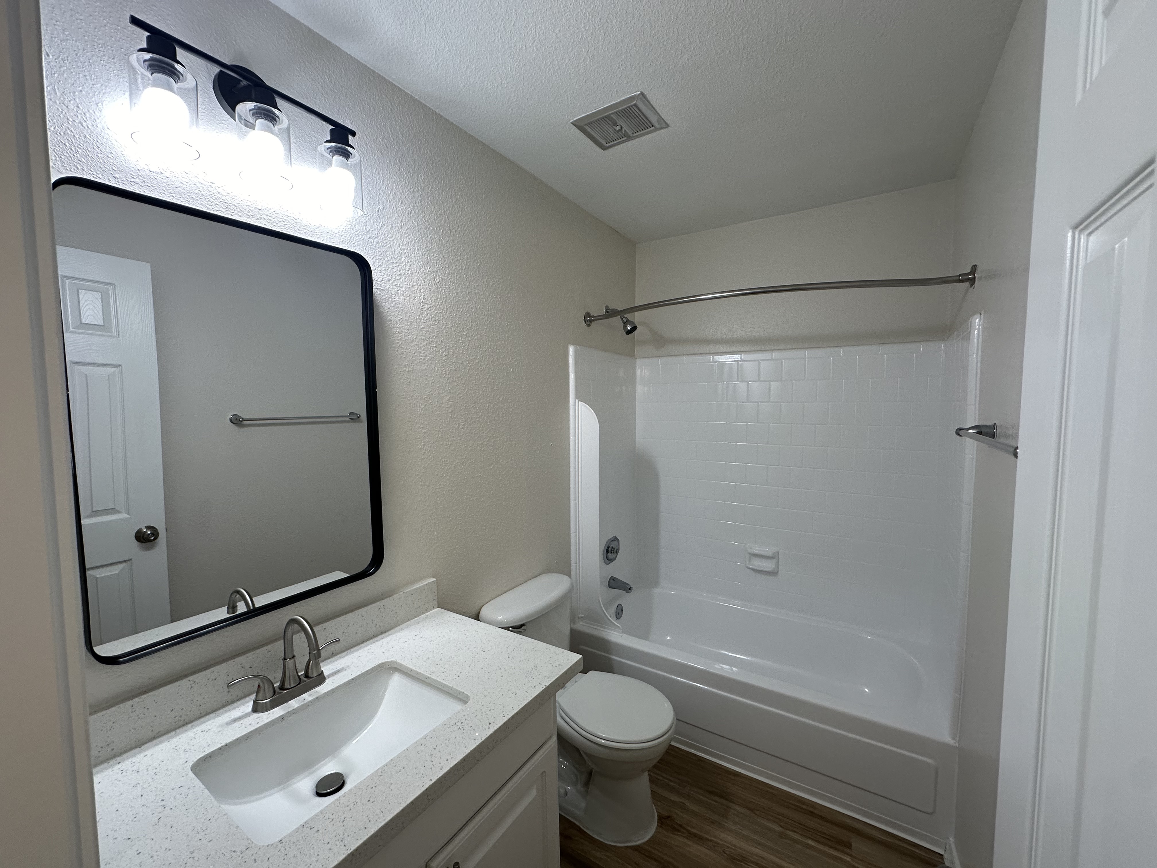 Bright and modern bathroom featuring a sleek vanity, stylish mirror, and elegant lighting.