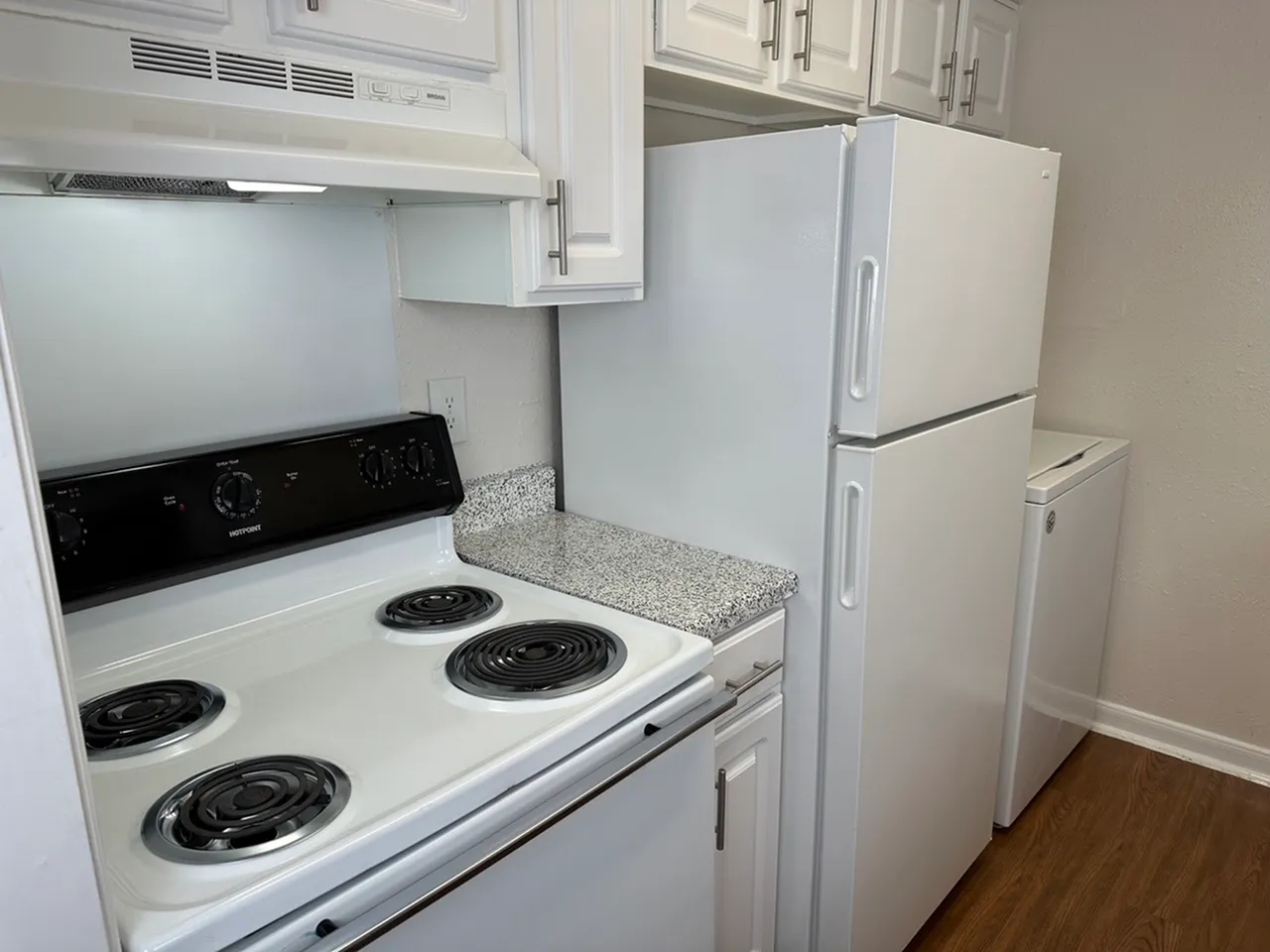 Modern kitchen with sleek white appliances, spacious cabinets, and elegant countertops.