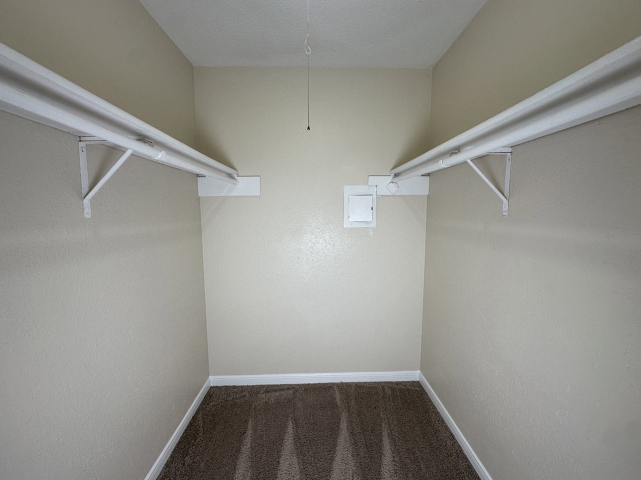 Spacious walk-in closet with ample shelving, ideal for organized storage and maximizing space.