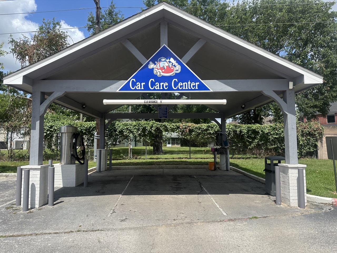 Inviting outdoor car care center with a spacious, sheltered cleaning area, set against a backdrop of lush greenery.