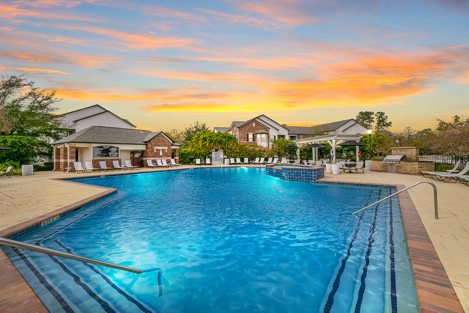 Luxurious pool area at sunset, featuring crystal-clear waters, elegant lounge chairs, and a charming clubhouse, perfect for relaxation and enjoyment.