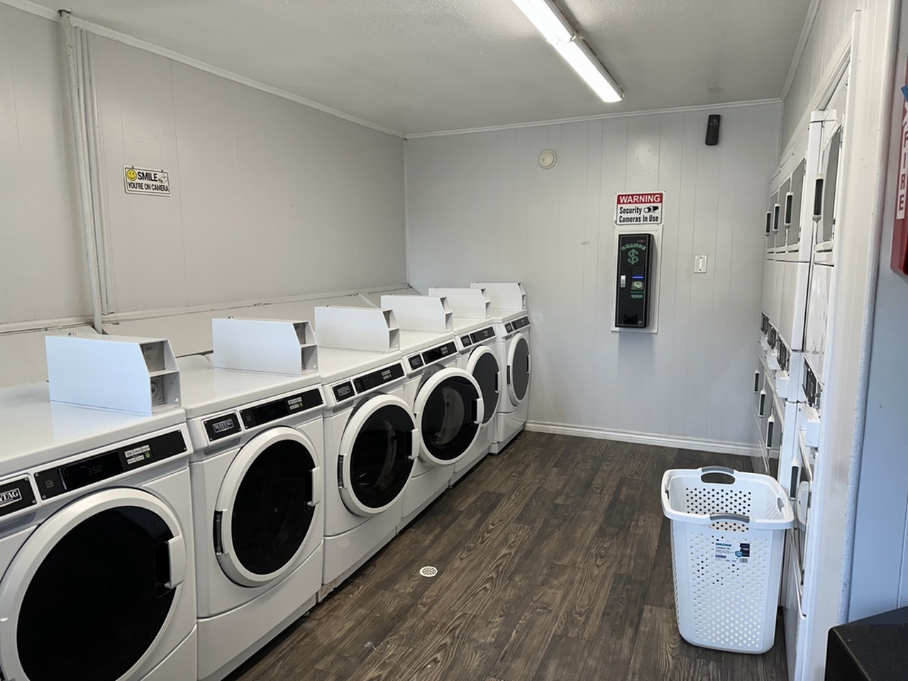 Efficient and modern laundry room featuring multiple washing and drying machines and ample space, ideal for convenient apartment living.