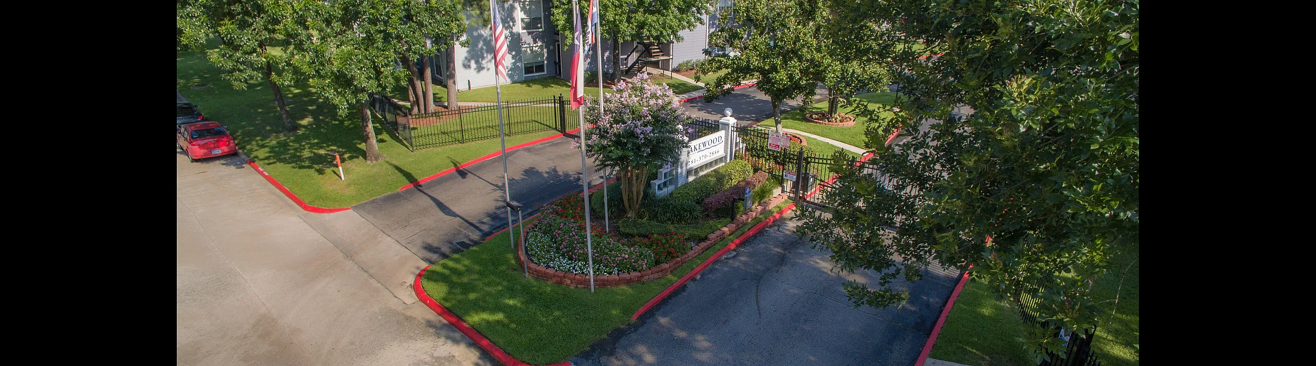 Inviting apartment entrance with manicured landscaping, vibrant flowers, and a welcoming gated entry in a serene neighborhood.