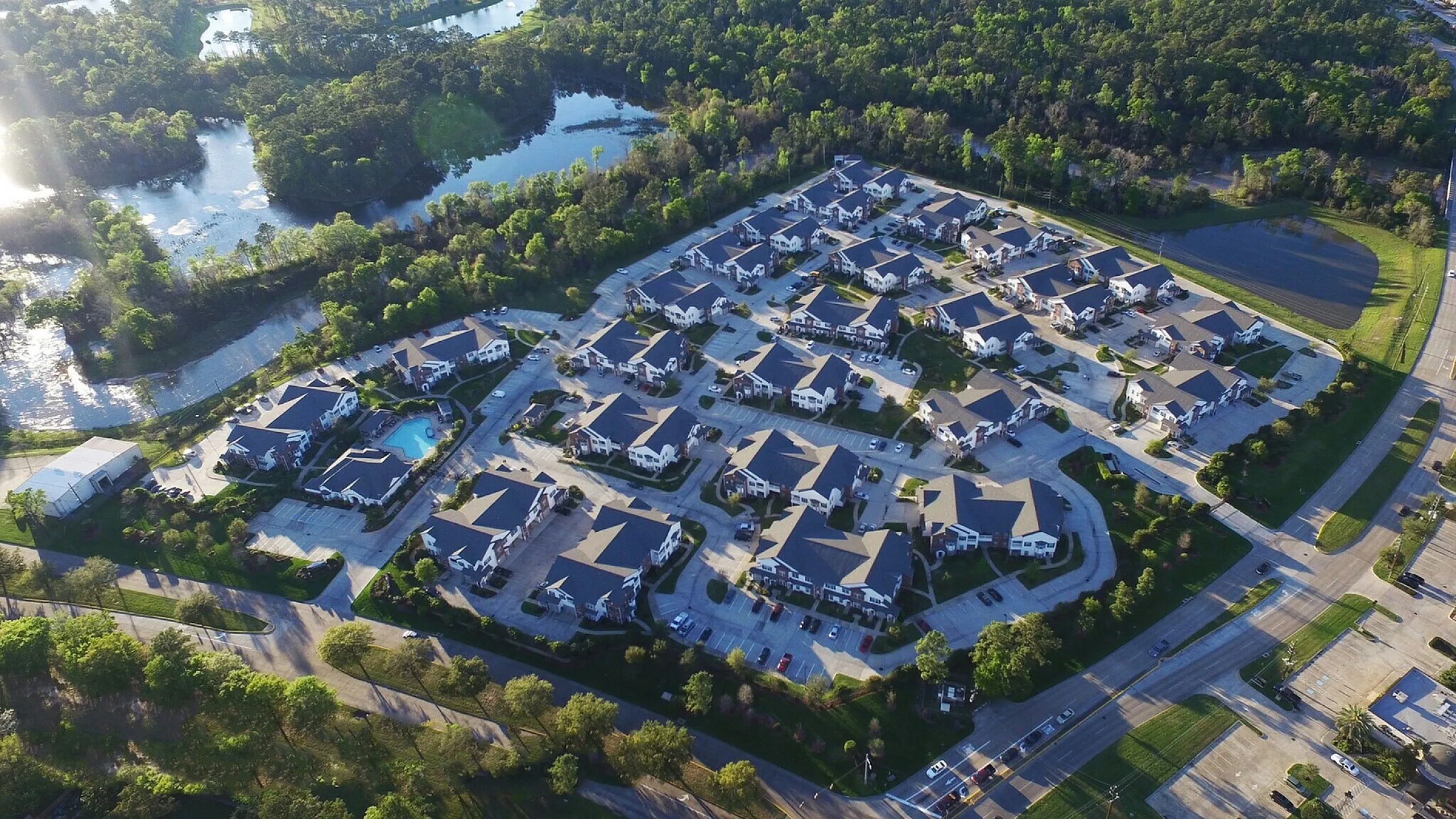 Picturesque aerial view of a serene residential neighborhood surrounded by lush greenery and tranquil water features, offering an idyllic and peaceful living environment.