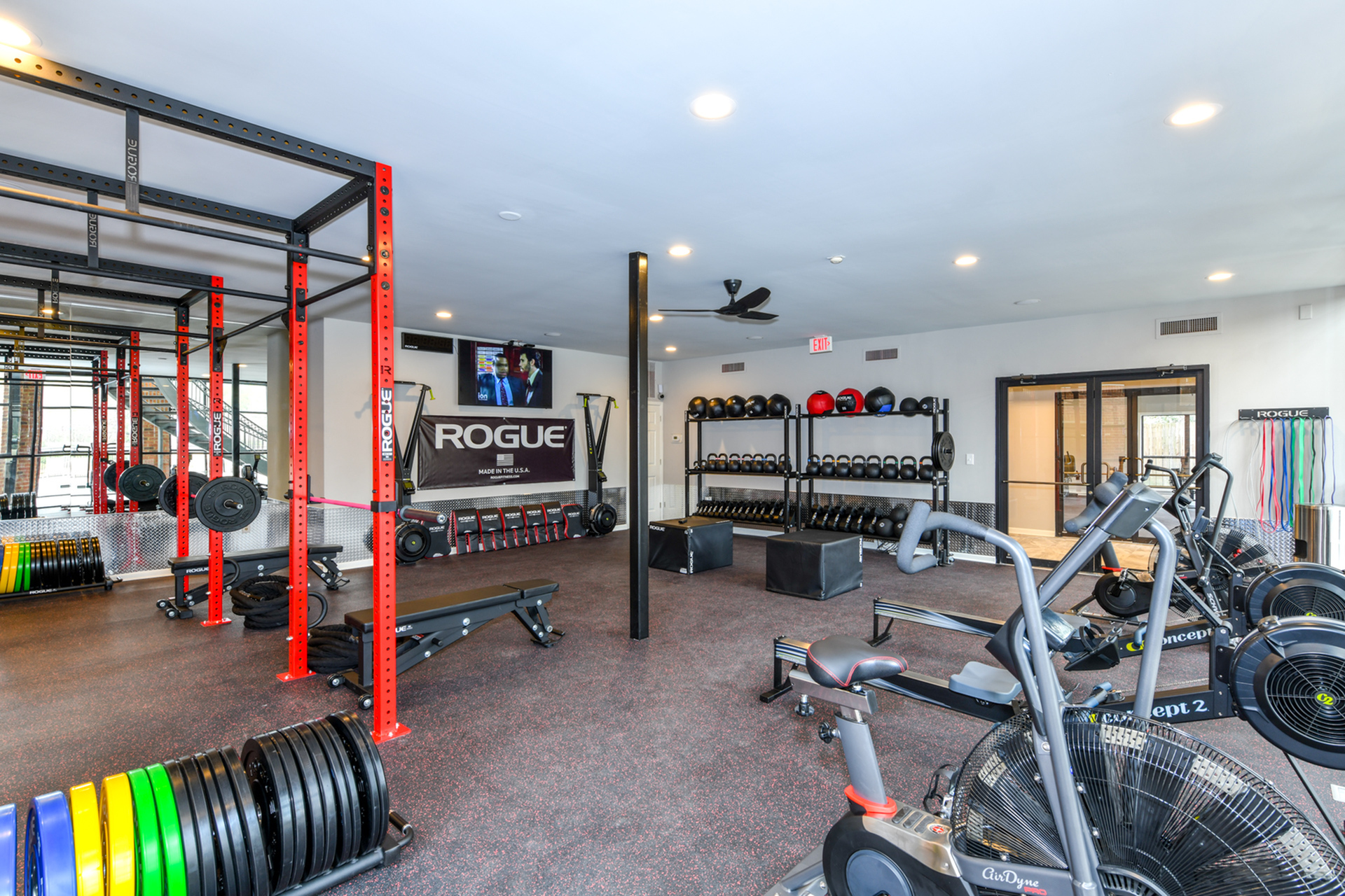 Bright and modern fitness center with state-of-the-art equipment, vibrant weight racks, and ample space for dynamic workouts.