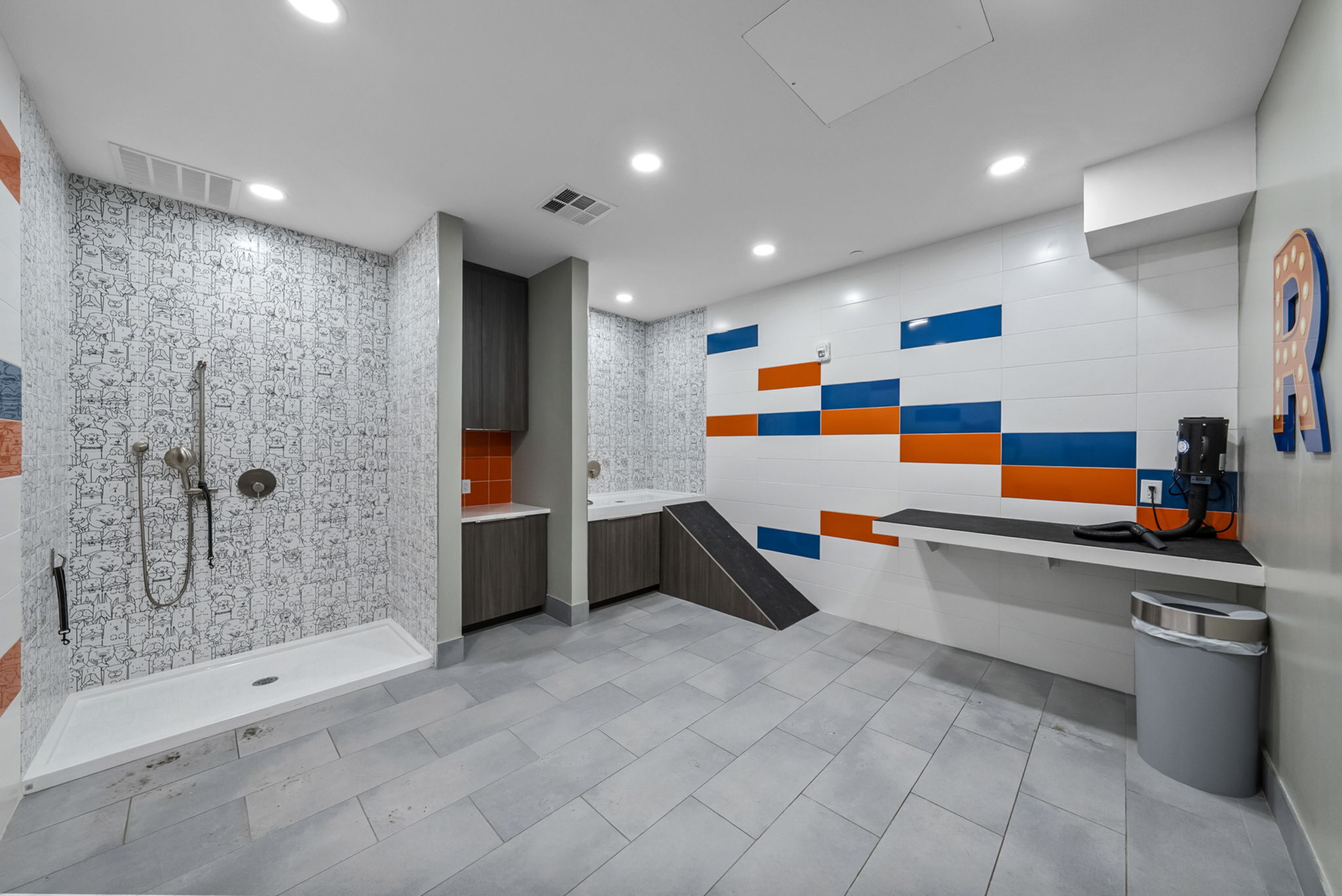 Contemporary pet wash room with colorful tiles, stylish washing area, and convenient storage space.