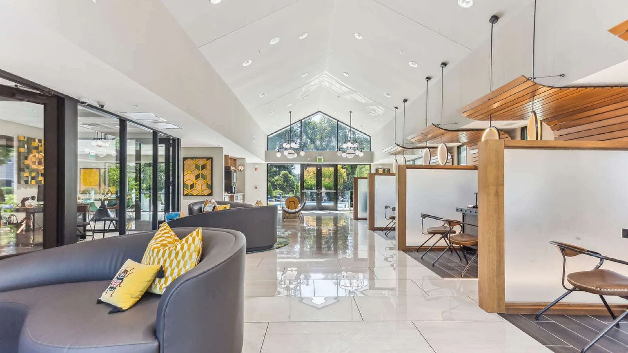 Elegant lobby with high ceilings, modern furniture, and large windows offering abundant natural light.