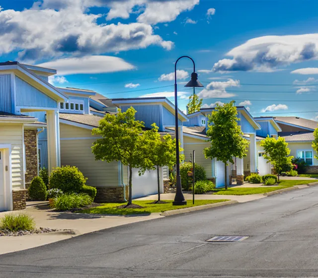 Charming suburban neighborhood with modern homes, lush greenery, and clear blue skies for a tranquil residential living experience.