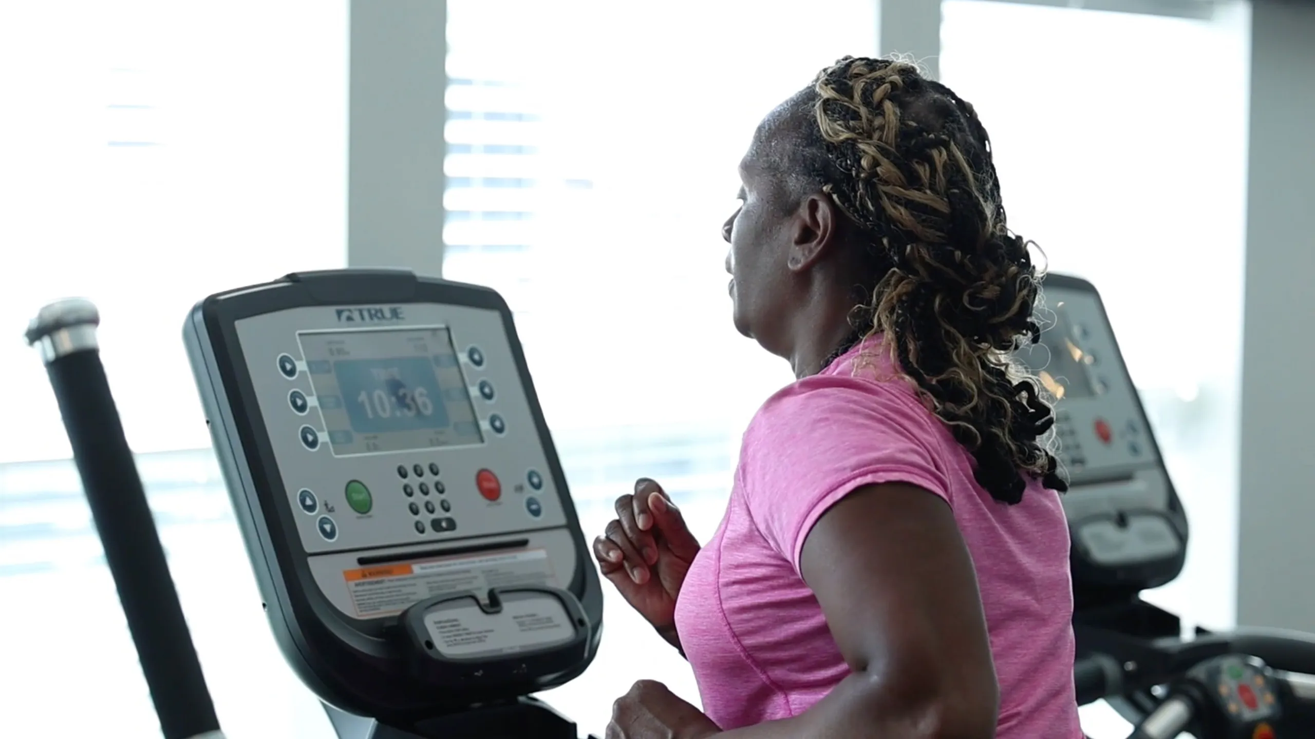 Modern fitness center with a runner enjoying a workout on a state-of-the-art treadmill, surrounded by natural light.