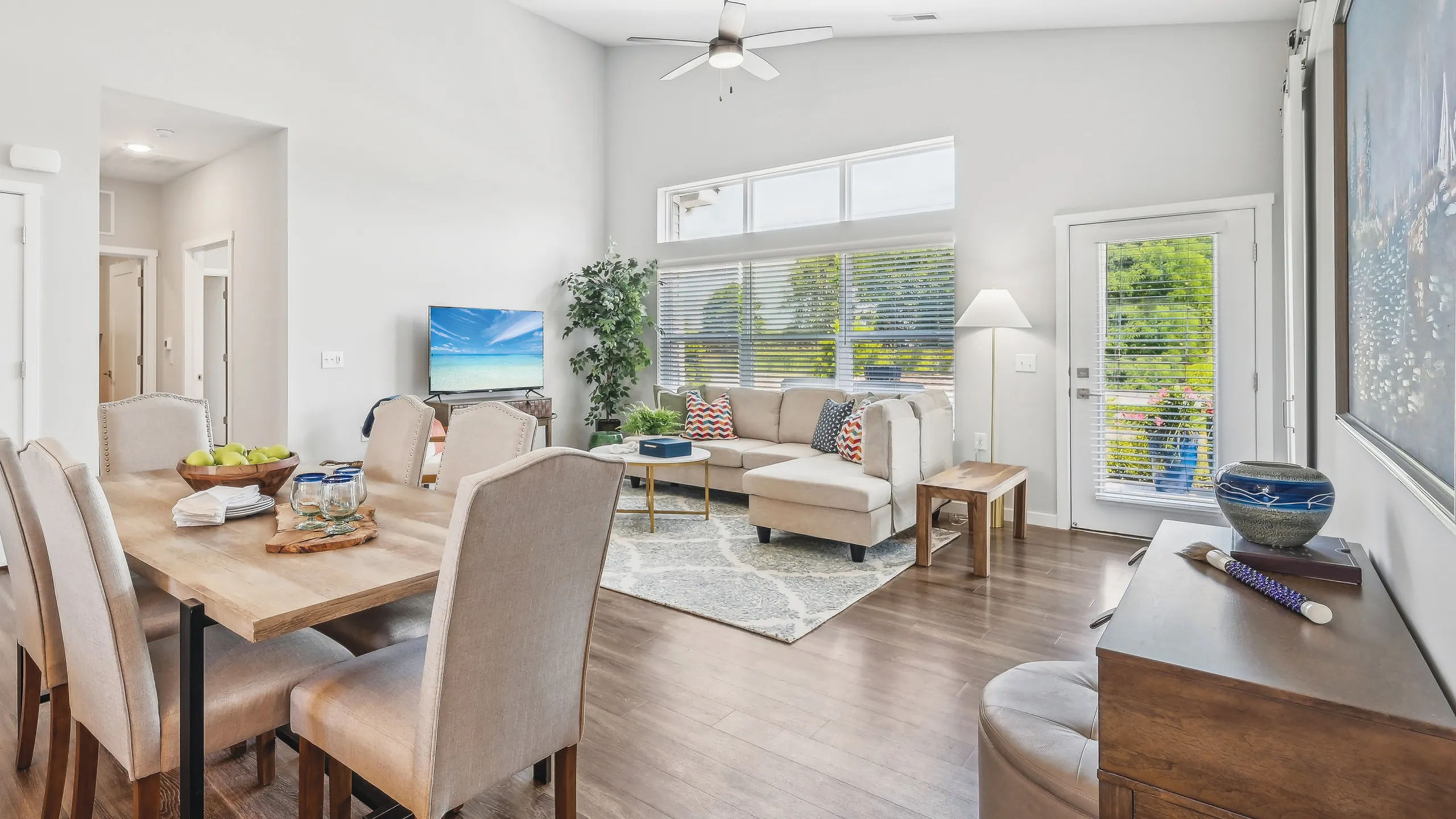 Bright and inviting living-dining area with modern decor, ample natural light, and stylish furniture.
