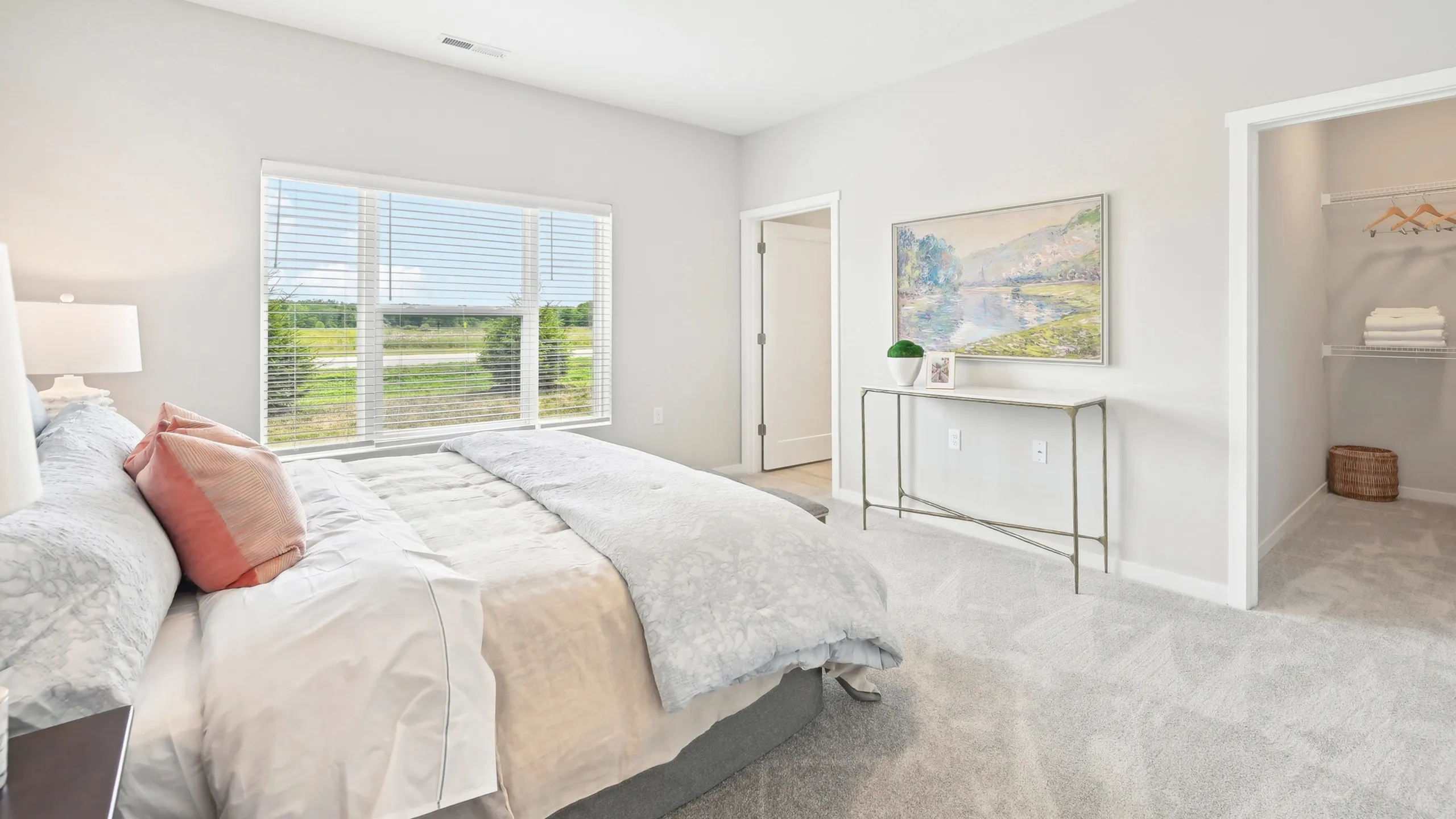 Bright and airy bedroom with large window, elegant decor, and spacious walk-in closet.