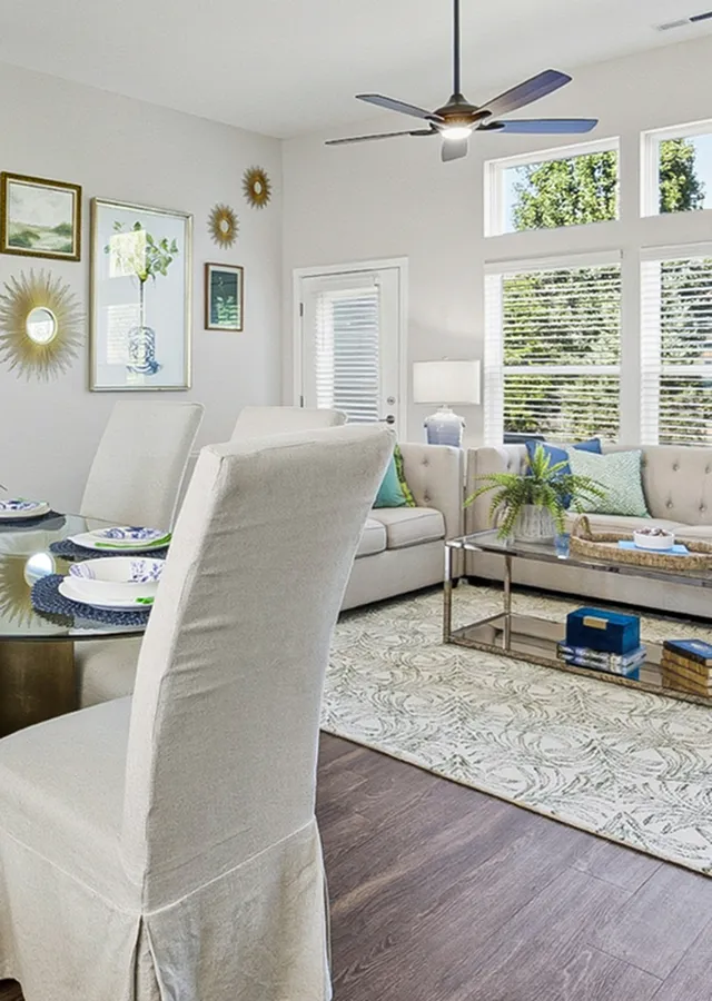 Elegantly designed living room with abundant natural light, modern decor, and a cozy dining area perfect for entertaining.