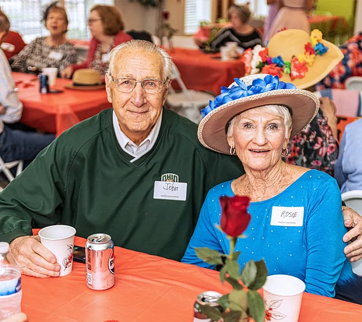 Lively community gathering with smiling seniors enjoying a social event. Cheerful atmosphere with vibrant hats and festive decorations.