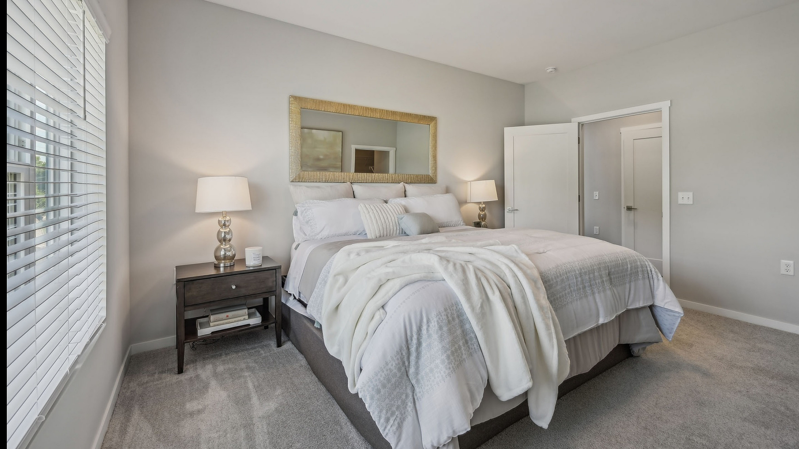 Inviting bedroom with plush bedding, elegant decor, and abundant natural light, perfect for relaxation.