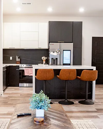 Modern open-concept living space with cozy seating, stylish kitchen island with barstools, and elegant decor.