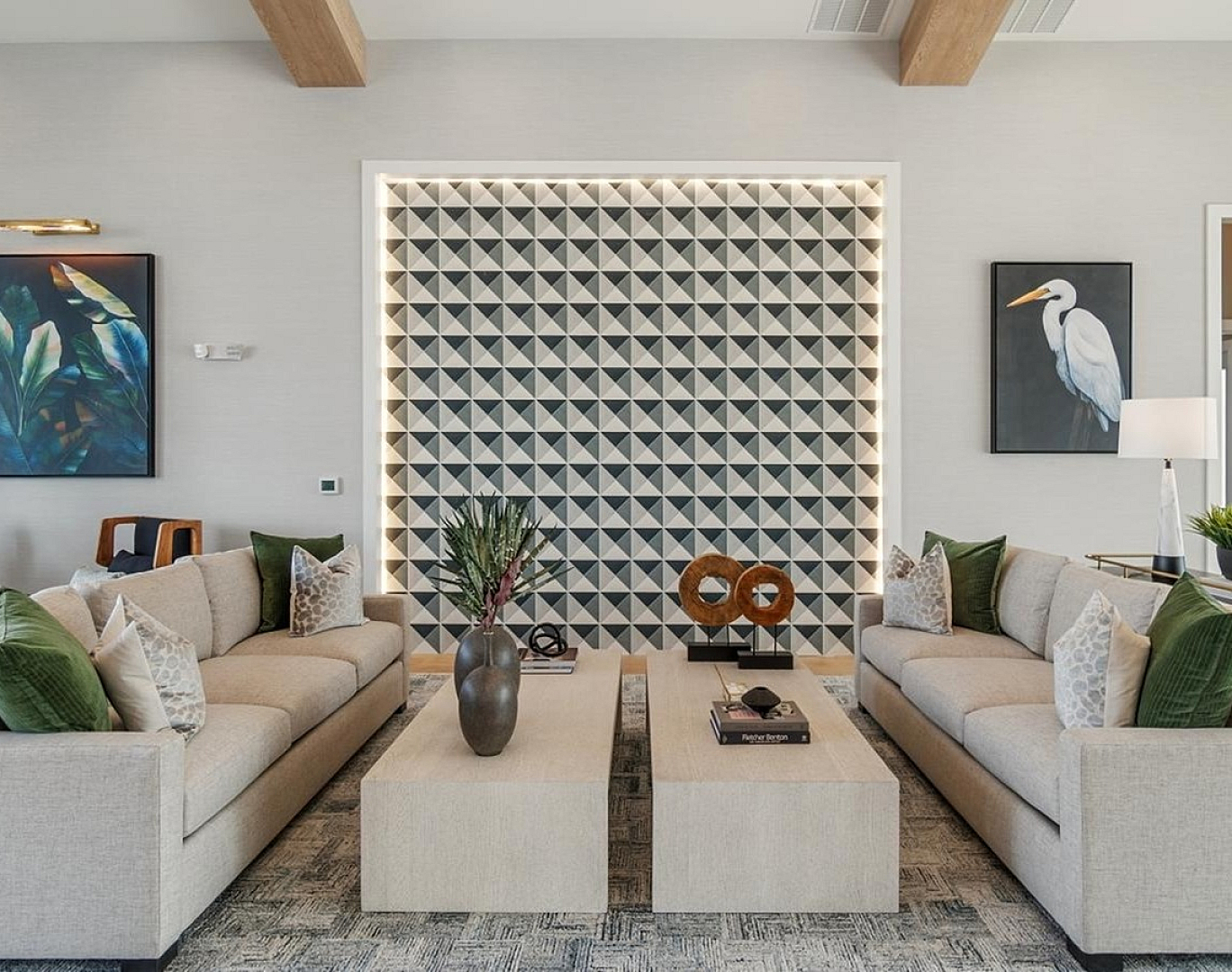 Modern living room with elegant sofas, geometric accent wall, and stylish decor, featuring lush greenery and chic artwork.