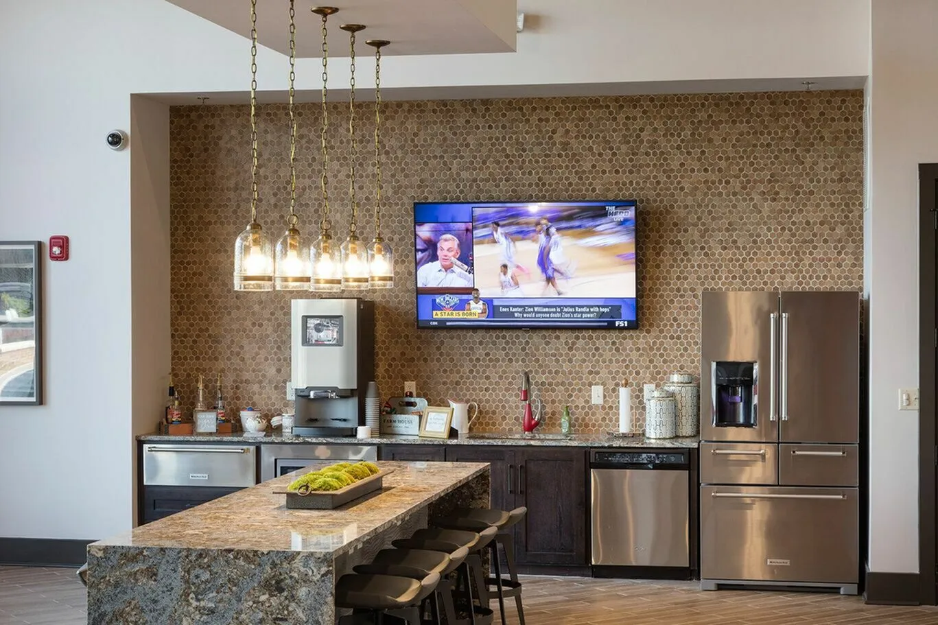 Modern kitchen area featuring sleek stainless steel appliances, stylish pendant lighting, and a granite island, with a cozy ambiance perfect for entertaining.