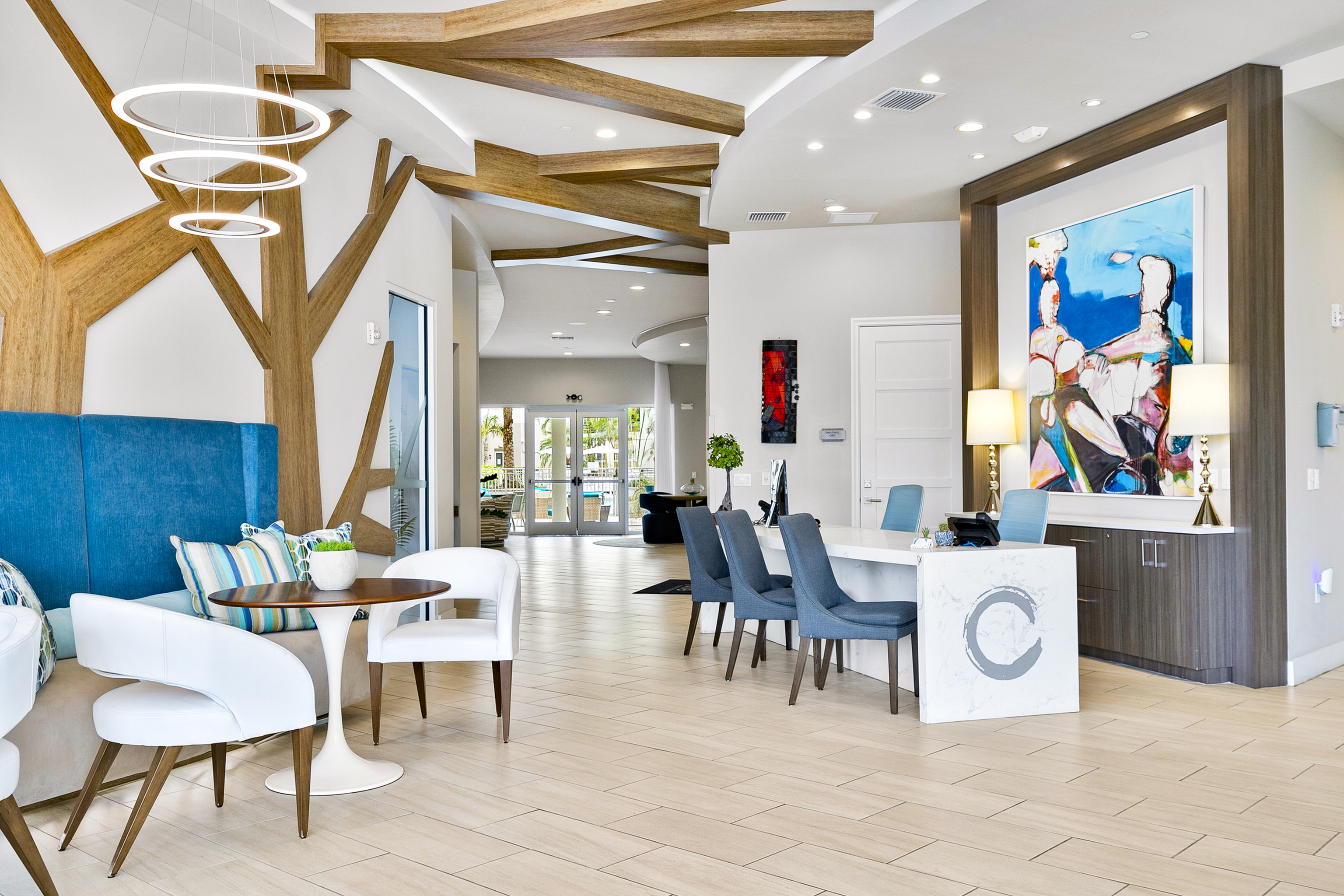 Chic and modern lobby featuring stylish blue seating, artistic decor, and unique wooden accents with elegant lighting.