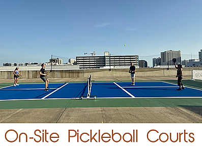 Vibrant on-site pickleball courts with players enjoying a match, set against a city skyline backdrop.