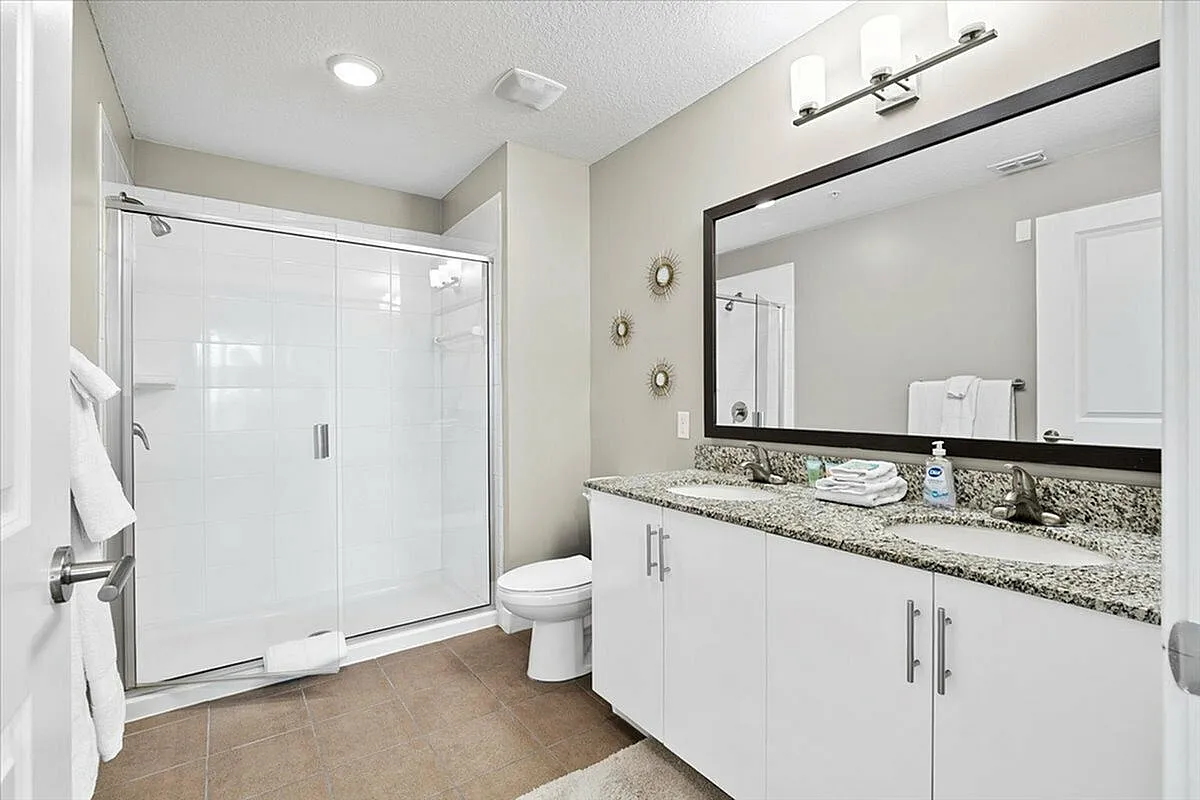 Elegant bathroom with sleek granite countertop, spacious shower, and modern decor accents. | City Side Apartments | Sarasota, FL