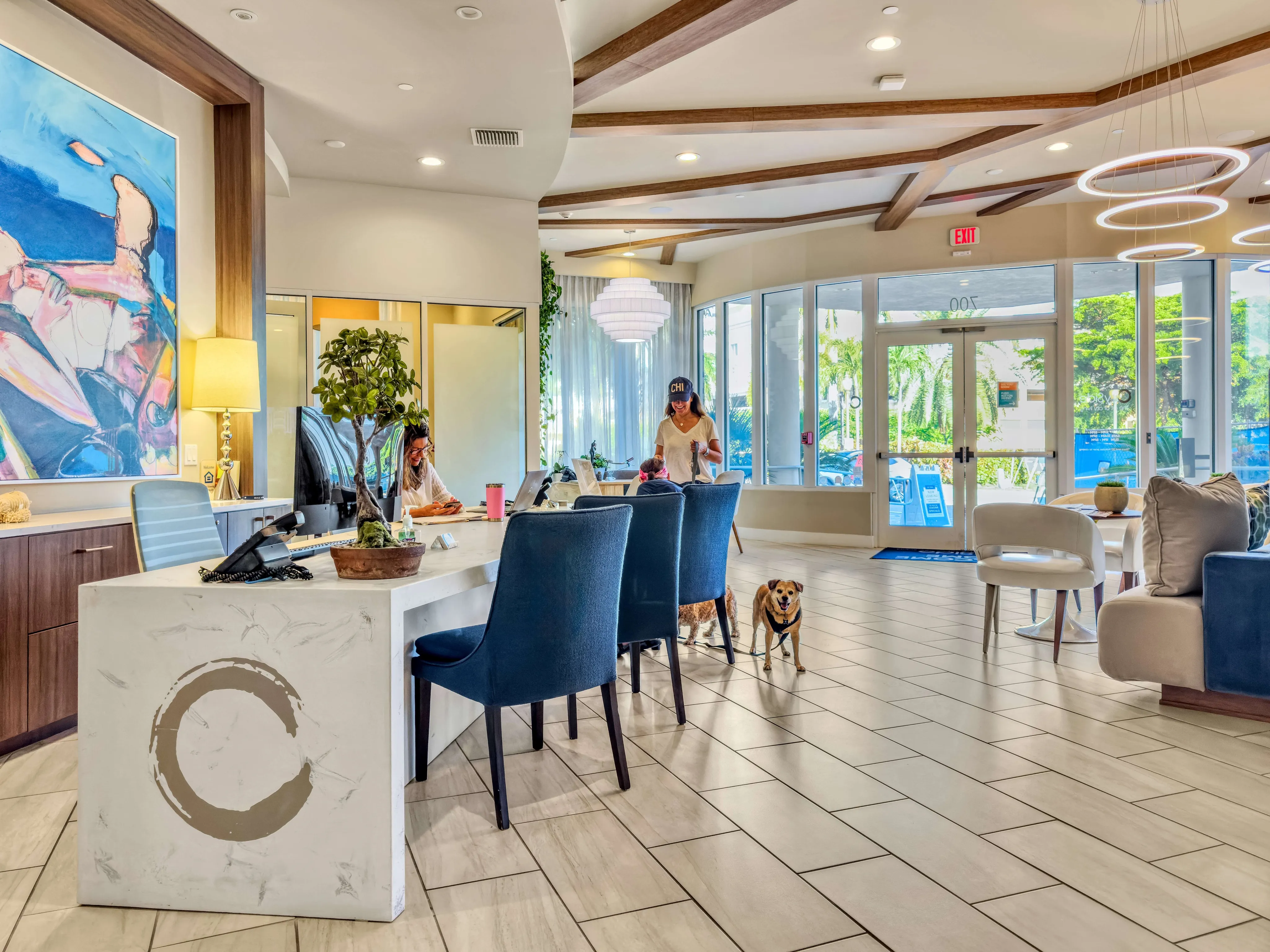 Inviting apartment lobby featuring modern decor, elegant seating, vibrant artwork, and abundant natural light.