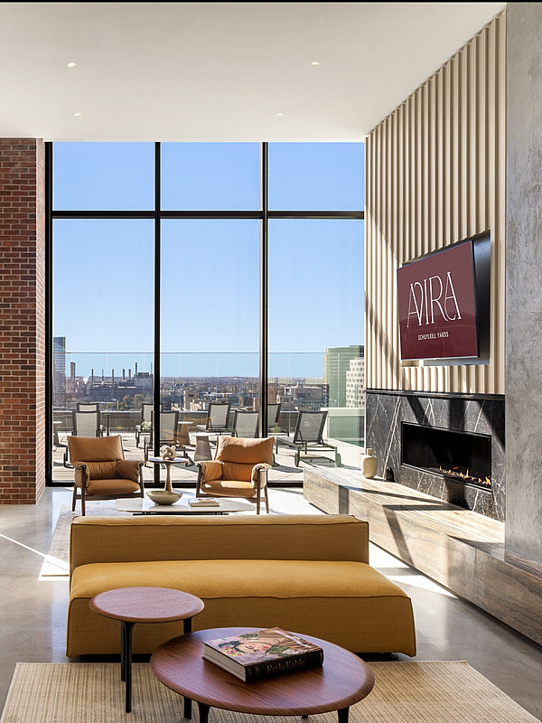 Luxurious living room with modern decor, expansive floor-to-ceiling windows offering stunning city views, and a cozy fireplace.