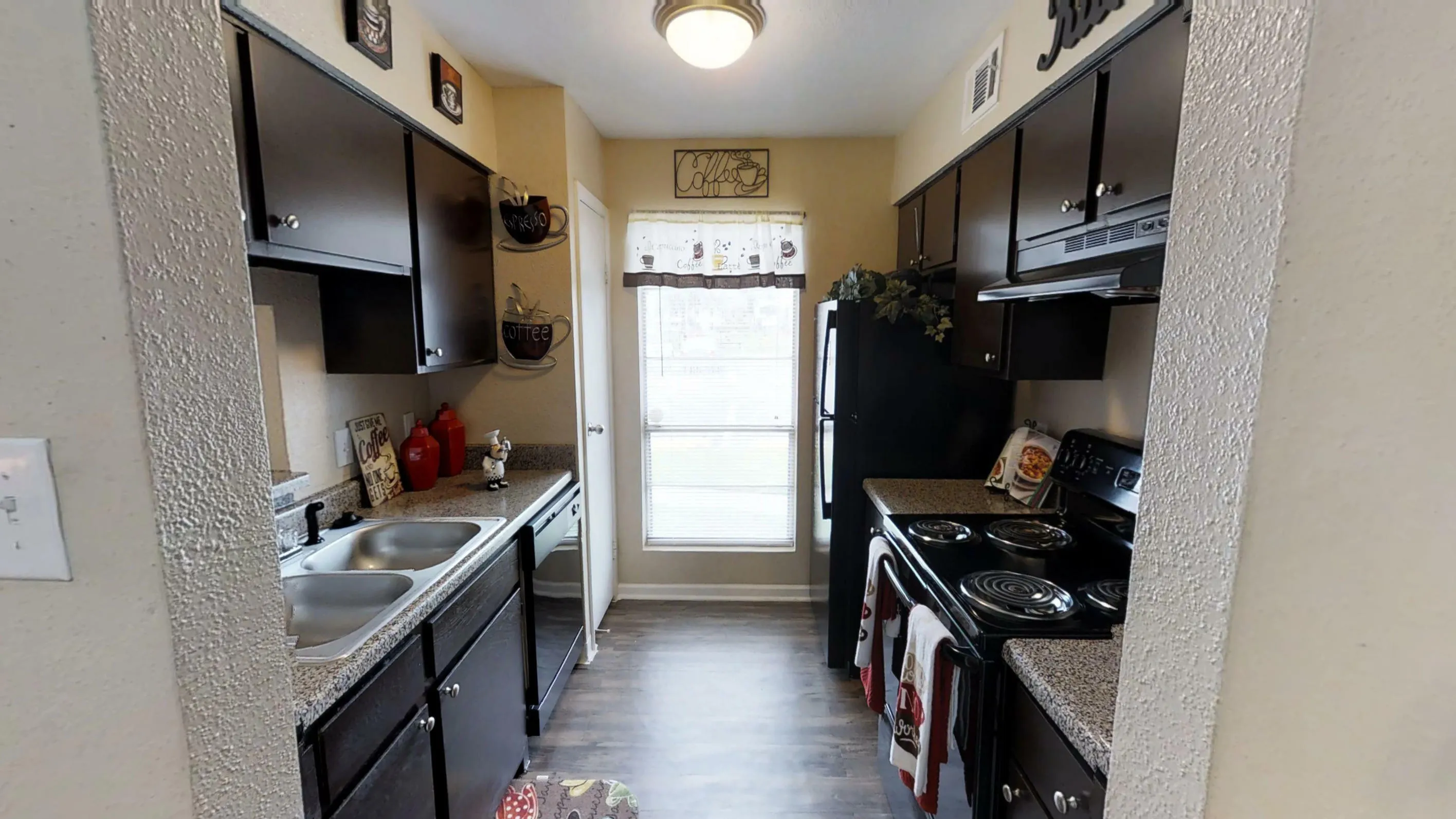 Charming kitchen with dark wood cabinetry, sleek countertops, and stylish coffee-themed decor creating a cozy atmosphere.