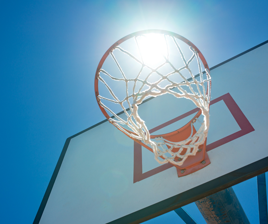 Vibrant outdoor basketball hoop under a clear blue sky, capturing the essence of sunny recreational spaces.