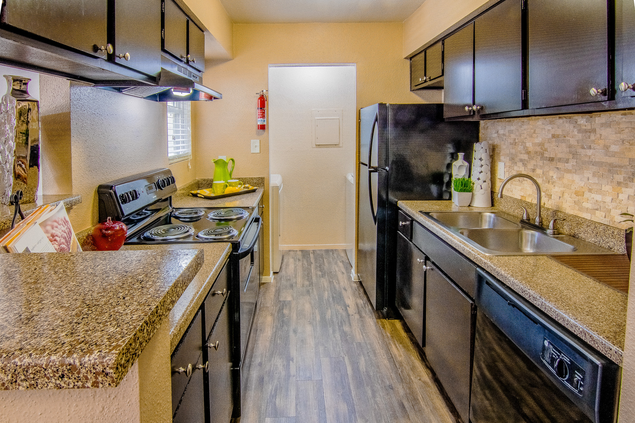 Modern kitchen with sleek black appliances, granite countertops, and stylish cabinetry, exuding elegance and functionality.