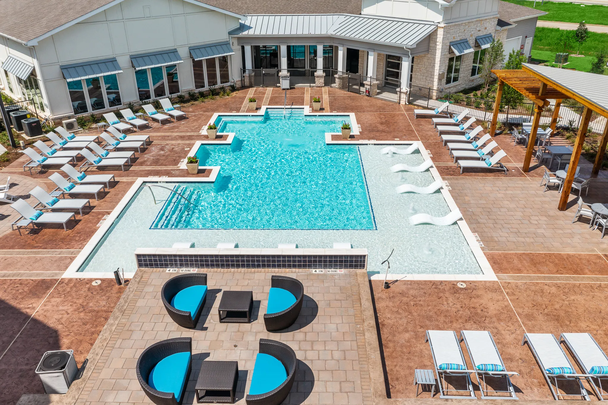 Luxurious outdoor pool area featuring sparkling blue water, elegant lounge chairs, and stylish shaded seating, perfect for relaxation and entertainment.