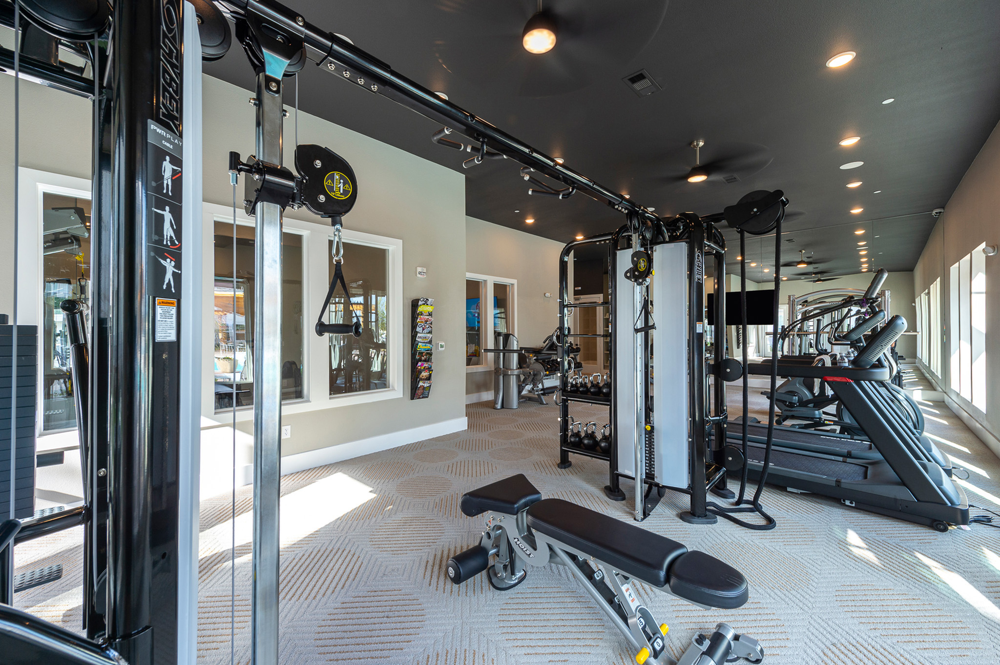 Modern fitness center featuring state-of-the-art gym equipment in a spacious, well-lit environment.