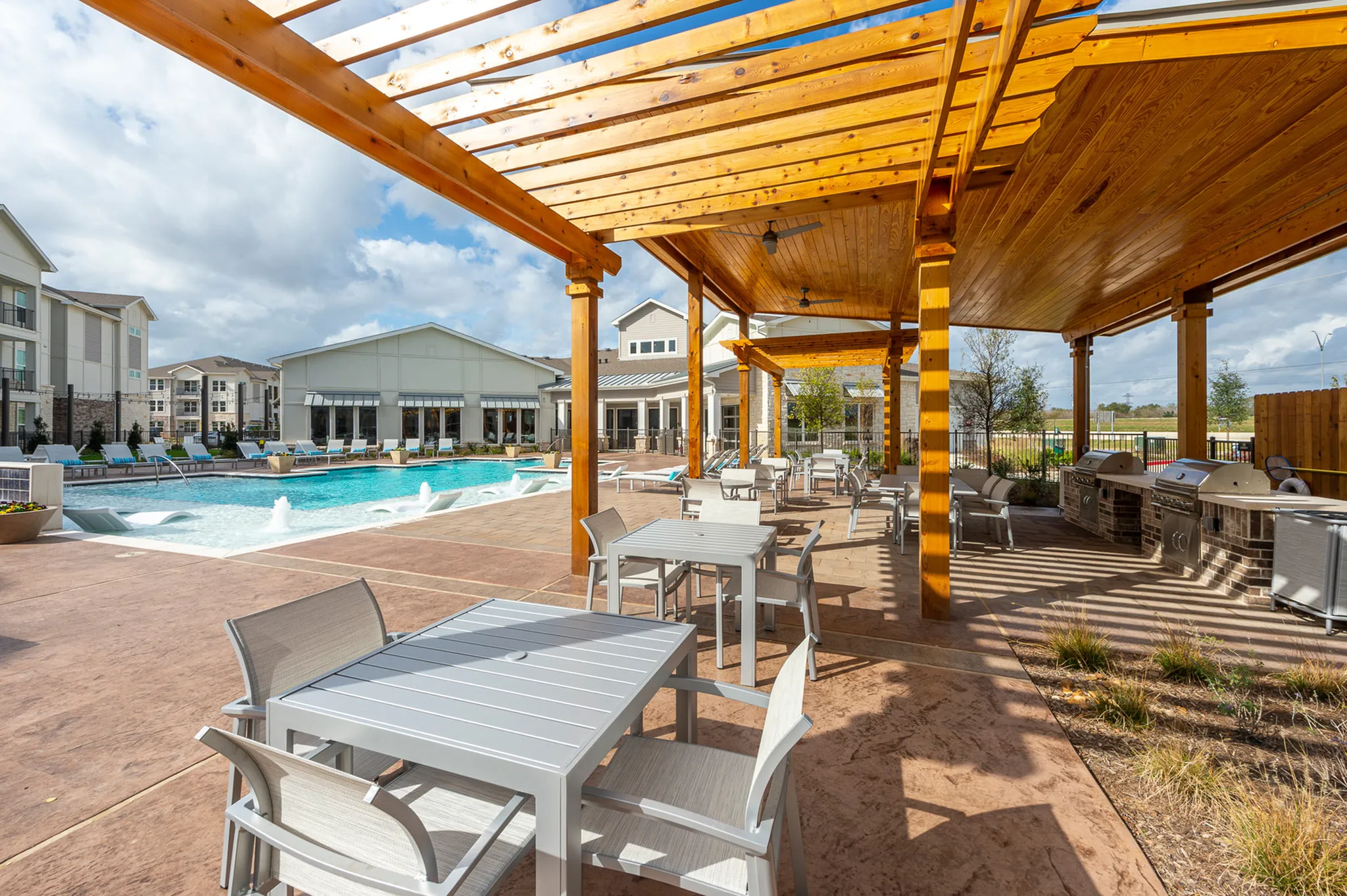 Chic outdoor patio with modern seating, stylish pergola, and inviting pool, perfect for relaxation and social gatherings.
