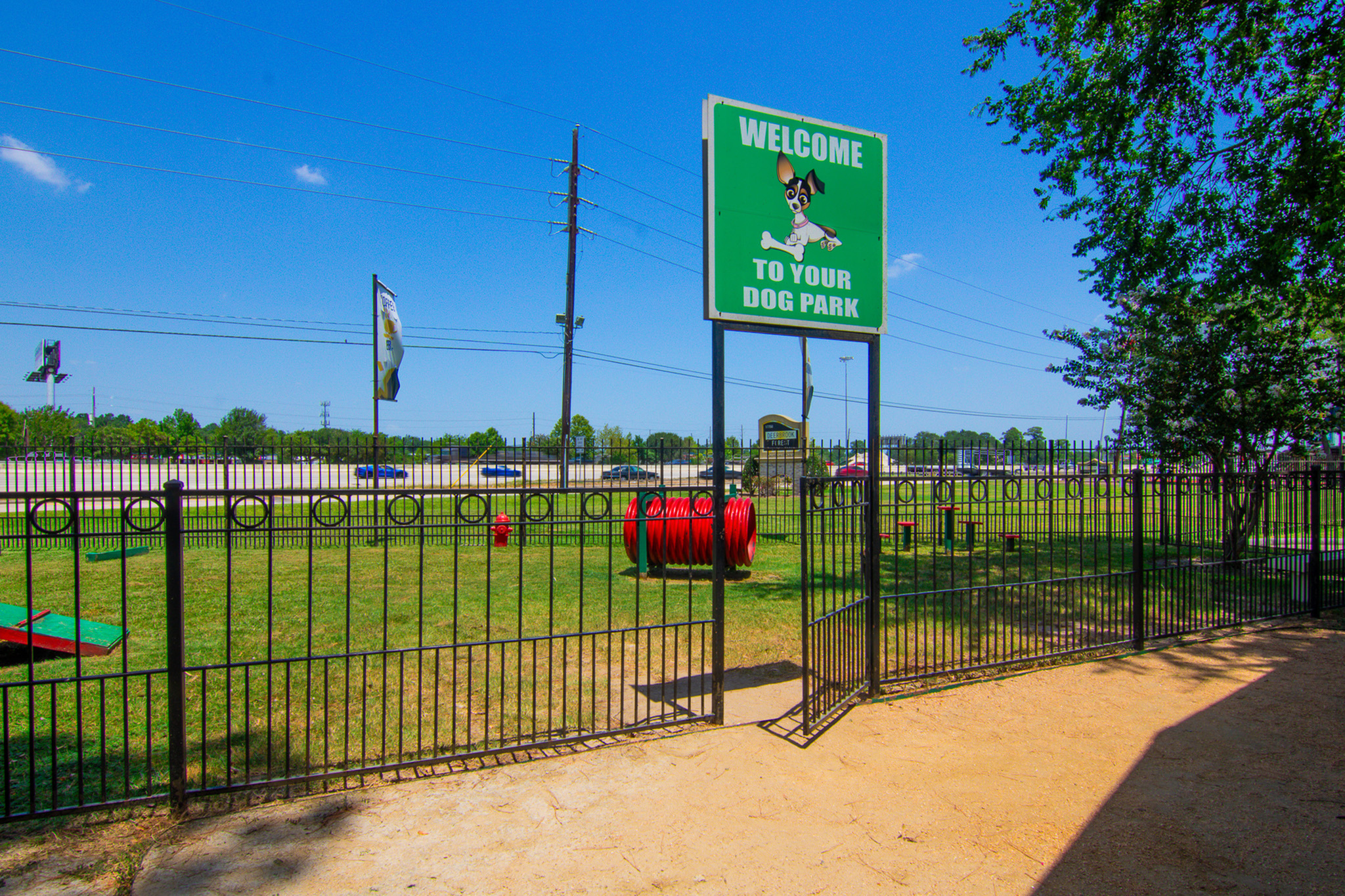 Inviting dog park with playful equipment and welcoming signage, ideal for pet-friendly community living.