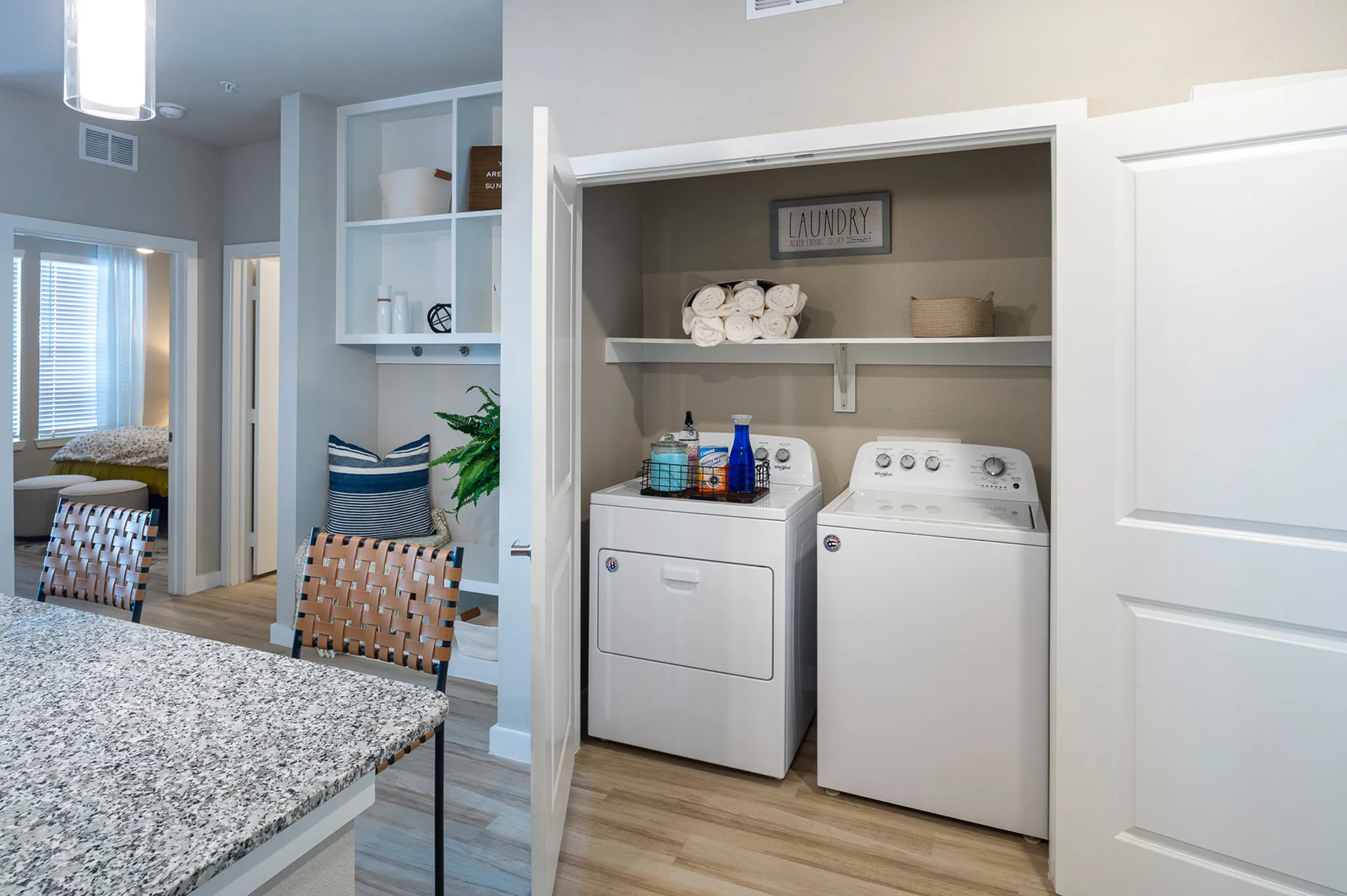 Modern apartment interior with in-unit laundry, featuring sleek washer and dryer, adjacent to a cozy living area with stylish seating and elegant decor.