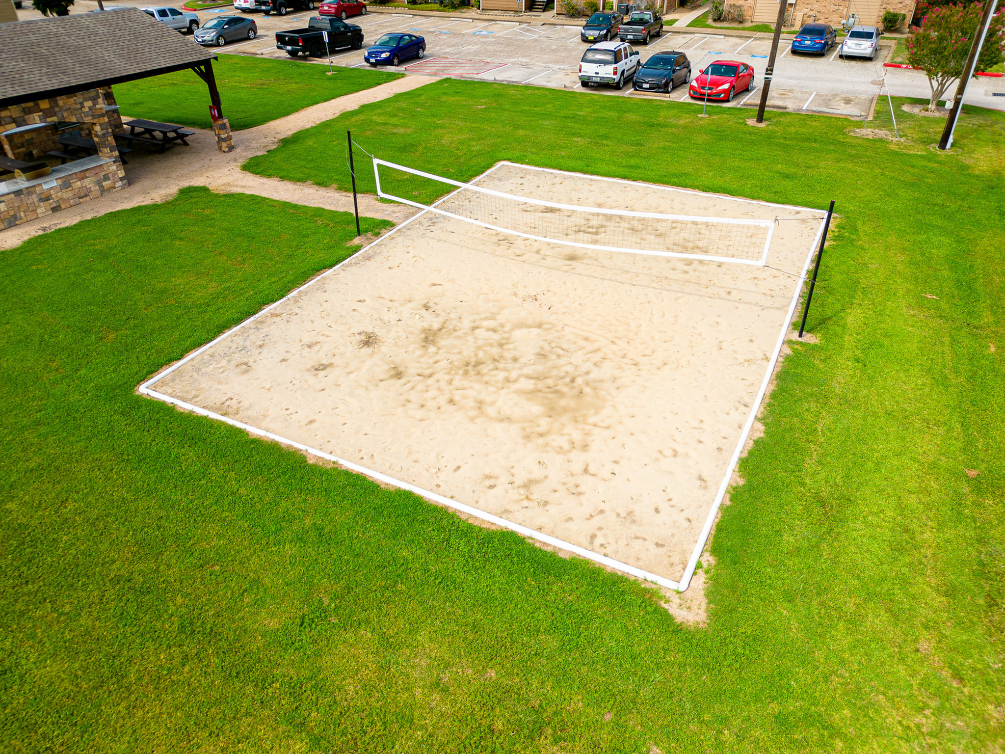 Inviting outdoor sand volleyball court surrounded by lush green grass, perfect for sports enthusiasts and community gatherings.