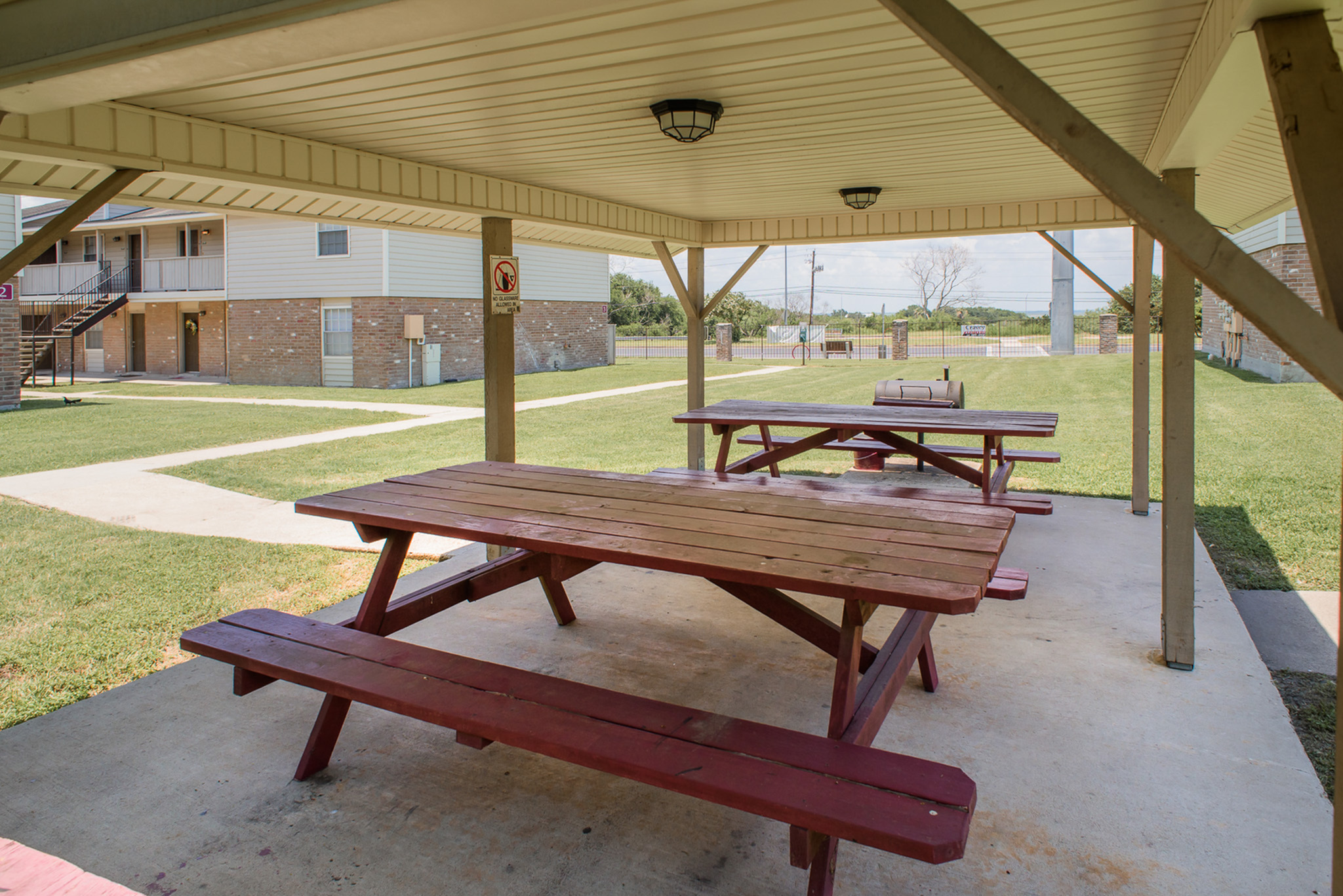 Charming outdoor gazebo with picnic tables, offering a relaxing communal space in a modern apartment complex.