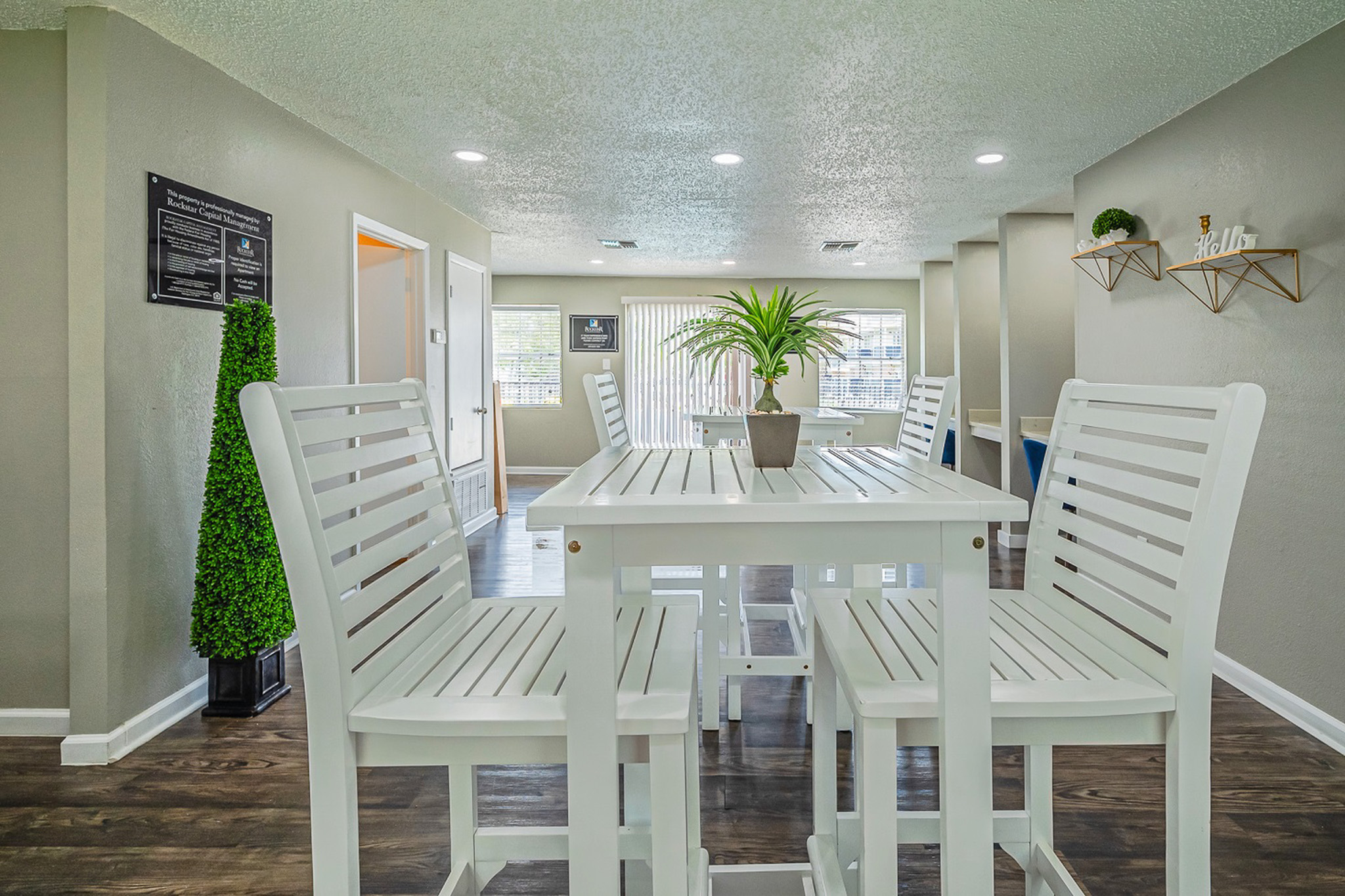 Bright and welcoming dining area with modern white furniture, lush indoor plant, and stylish decor accents.