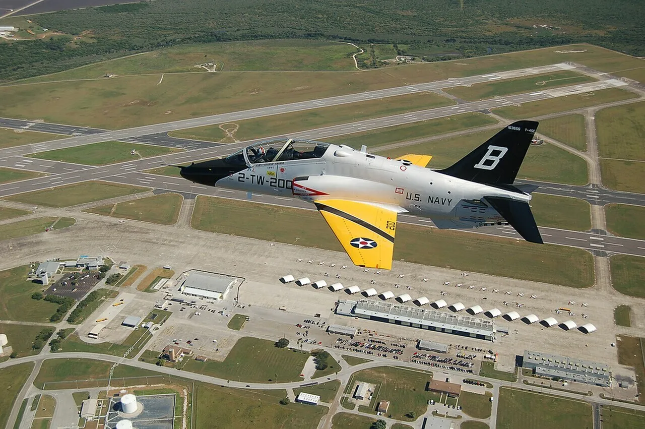 Dynamic aerial view of a U.S. Navy jet flying over an expansive airfield, showcasing precision and power.