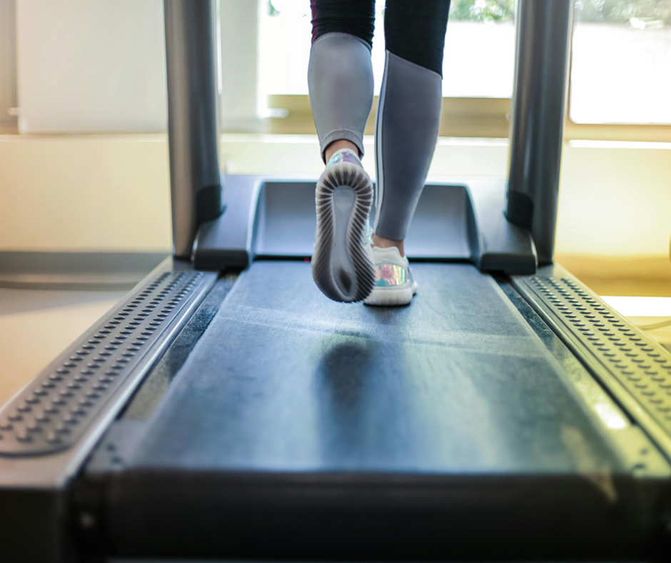 Invigorating view of a person jogging on a treadmill in a bright, modern fitness space.