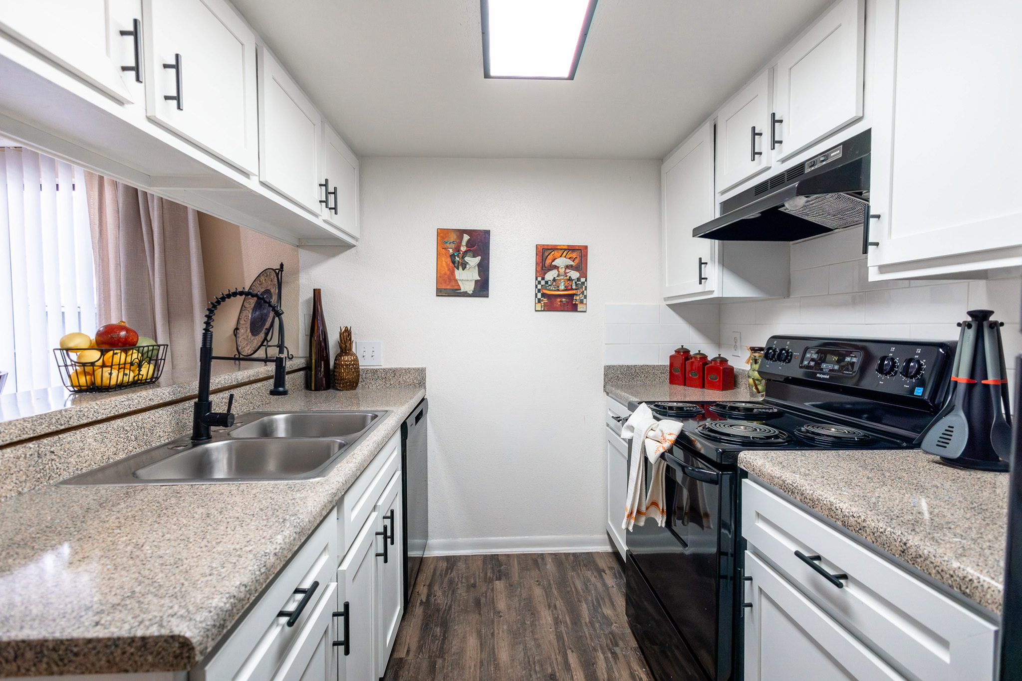 Updated kitchen with modern countertops, double sink, and upgraded fixtures at Waterchase Apartments