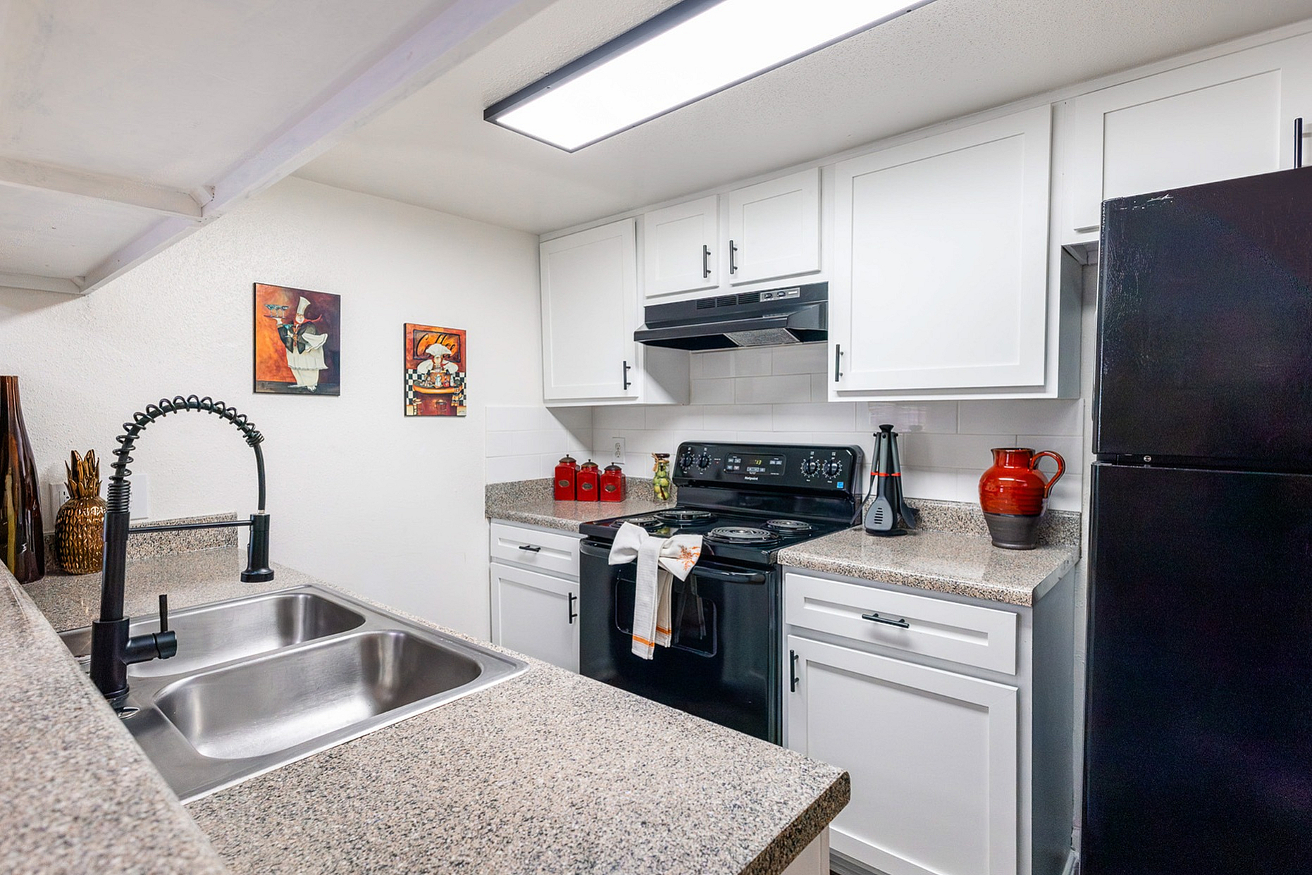 Modern kitchen with sleek countertops, elegant fixtures, and vibrant decor, offering ample cooking space.