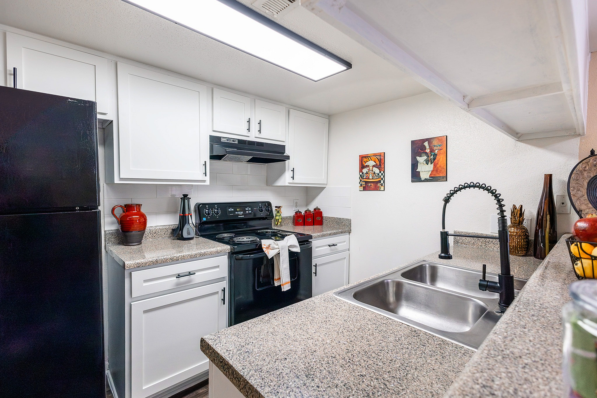Kitchen pass-through with double sink overlooking living area at Waterchase Apartments in Humble