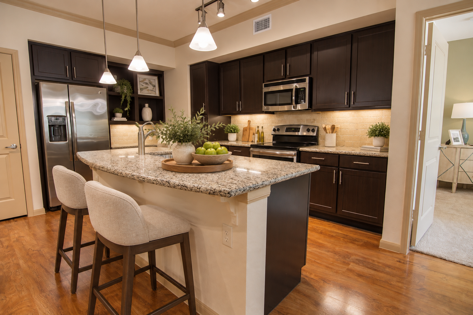 Modern kitchen with elegant granite countertops, sleek dark cabinetry, and cozy seating area, perfect for entertaining guests.