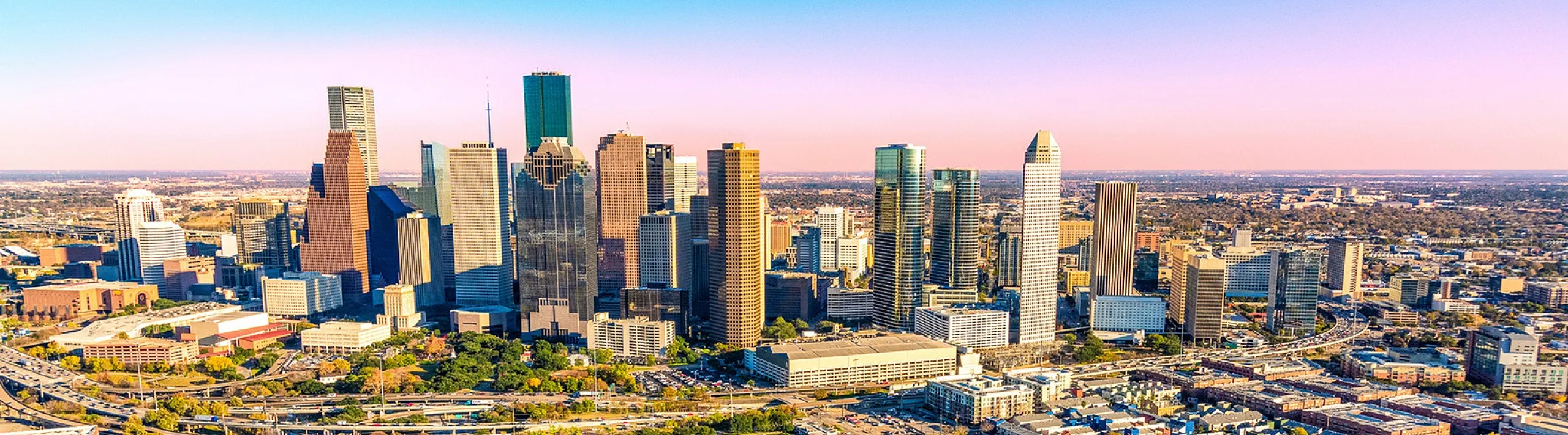 Stunning cityscape of Houston with iconic skyscrapers glowing under a colorful sunset sky, showcasing urban elegance and vibrant energy.
