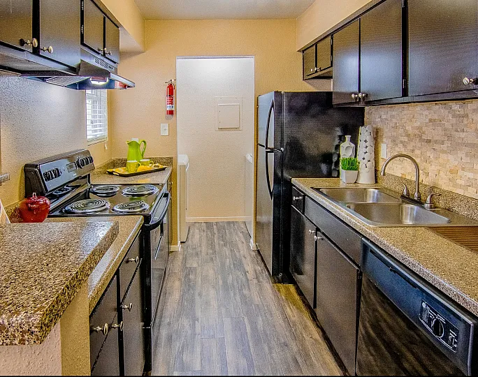 Charming kitchen with modern appliances, elegant dark cabinets, and warm granite countertops, perfect for culinary creativity.